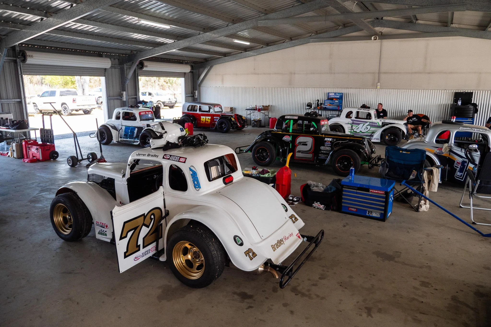 Race cars in a garage, with tools and equipment