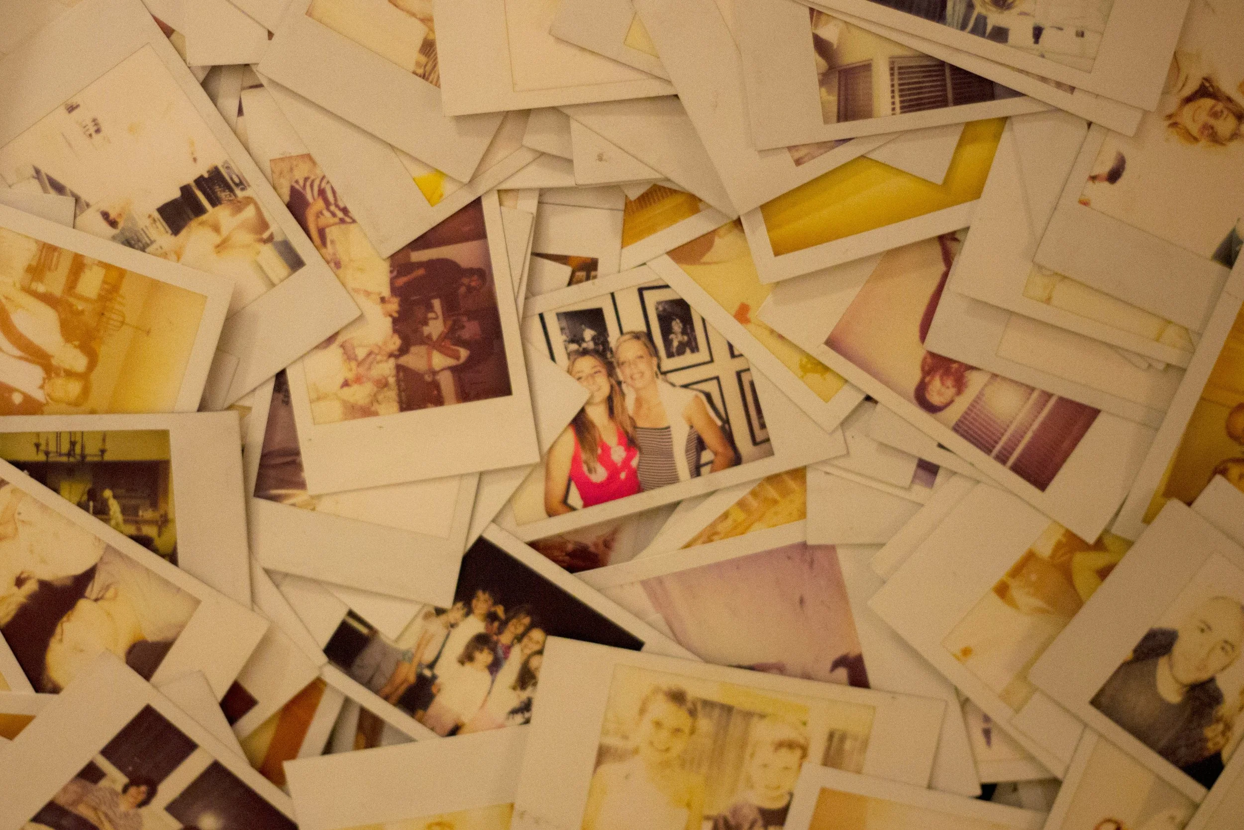 Person reflecting while looking through old family photo albums, representing nostalgia, memory, and emotional well-being.