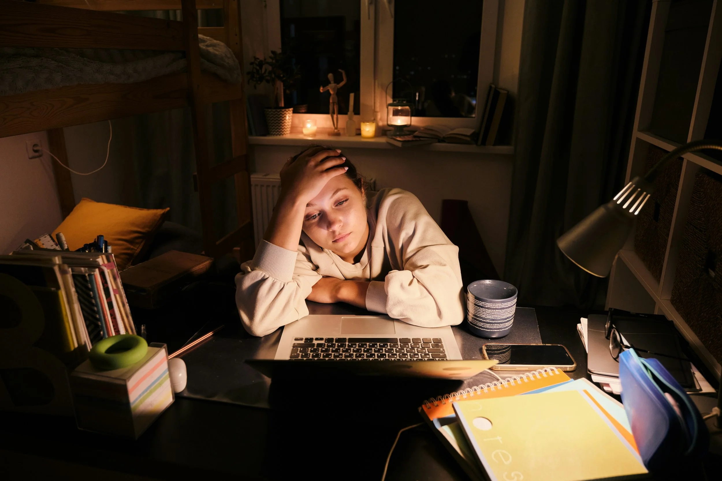 Woman working at a desk appearing composed but showing physical signs of stress, representing high functioning anxiety and hidden emotional overwhelm