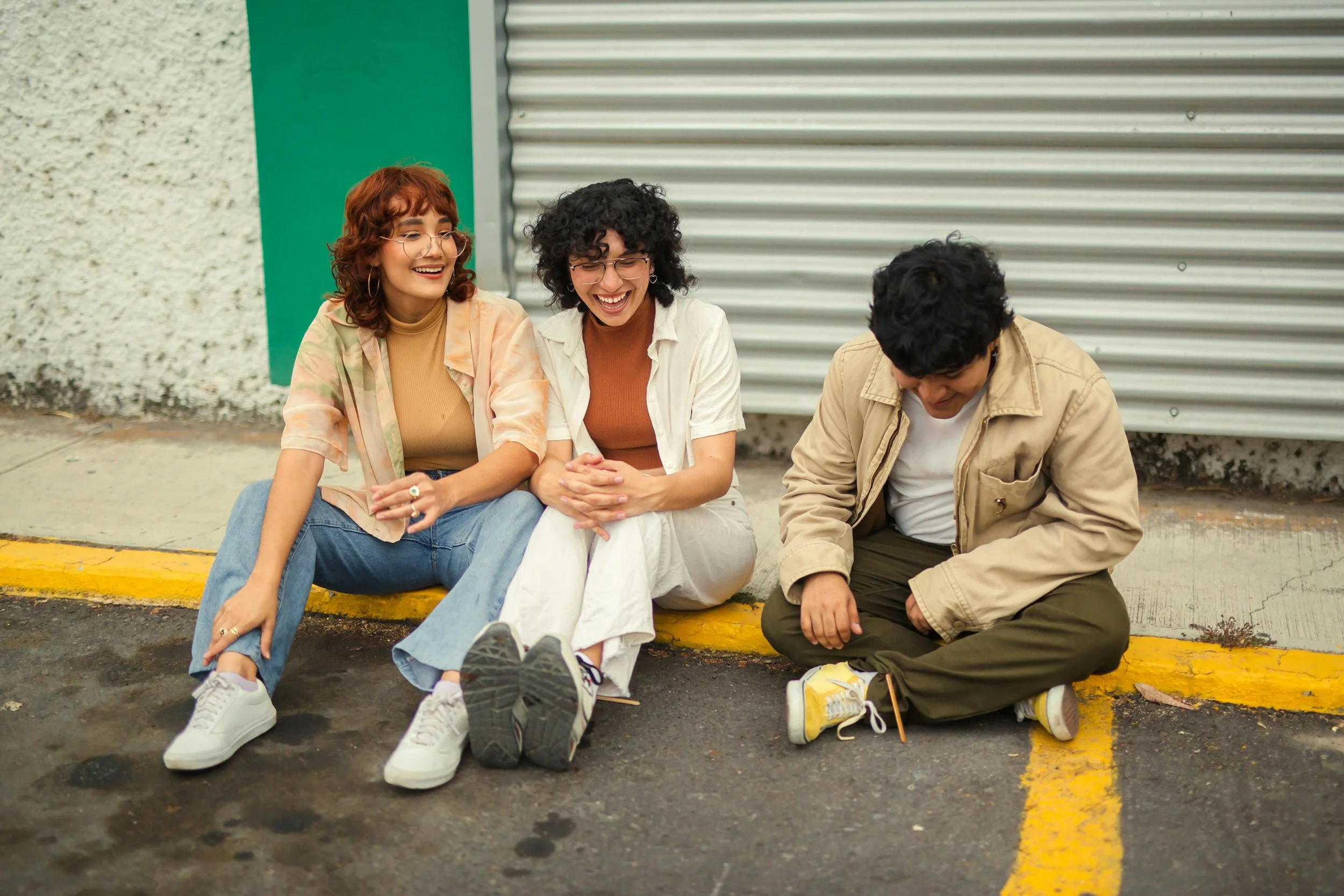 Person sitting quietly with a group of friends, representing the tendency to minimize personal needs and preferences in relationships.