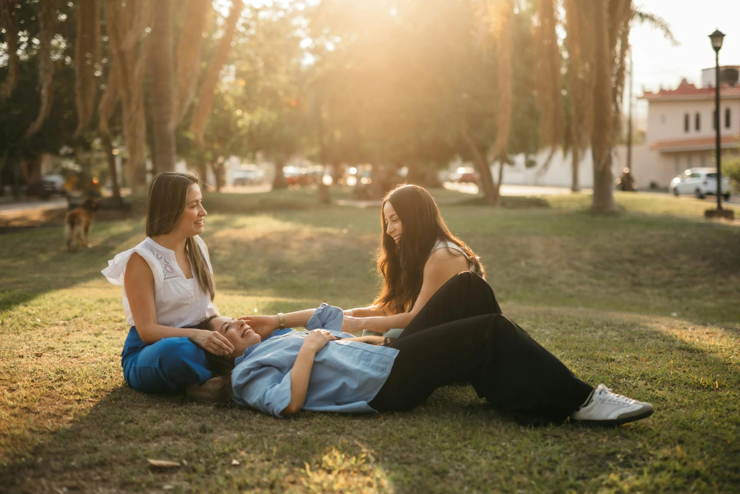 Adult woman sitting with sisters appearing emotionally exhausted while being the strong one in her family