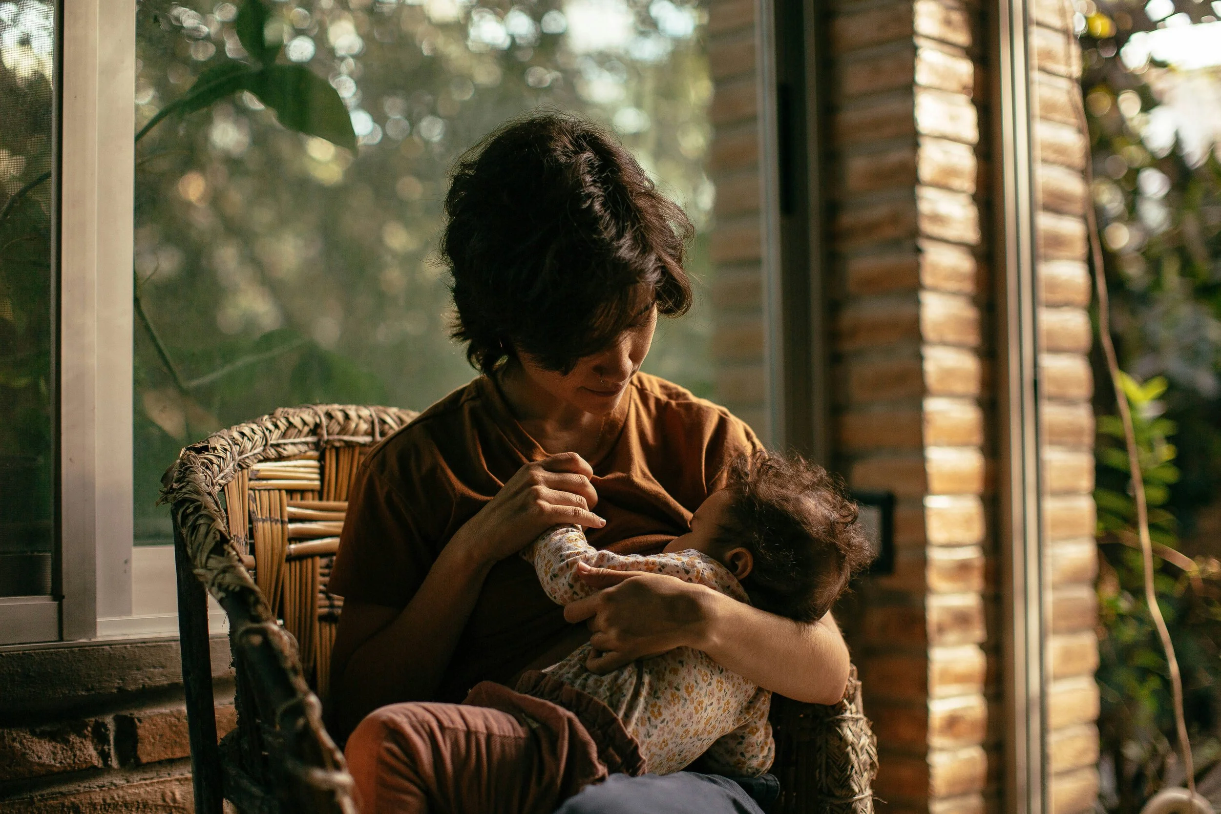 New mother holding her baby while experiencing postpartum anxiety.