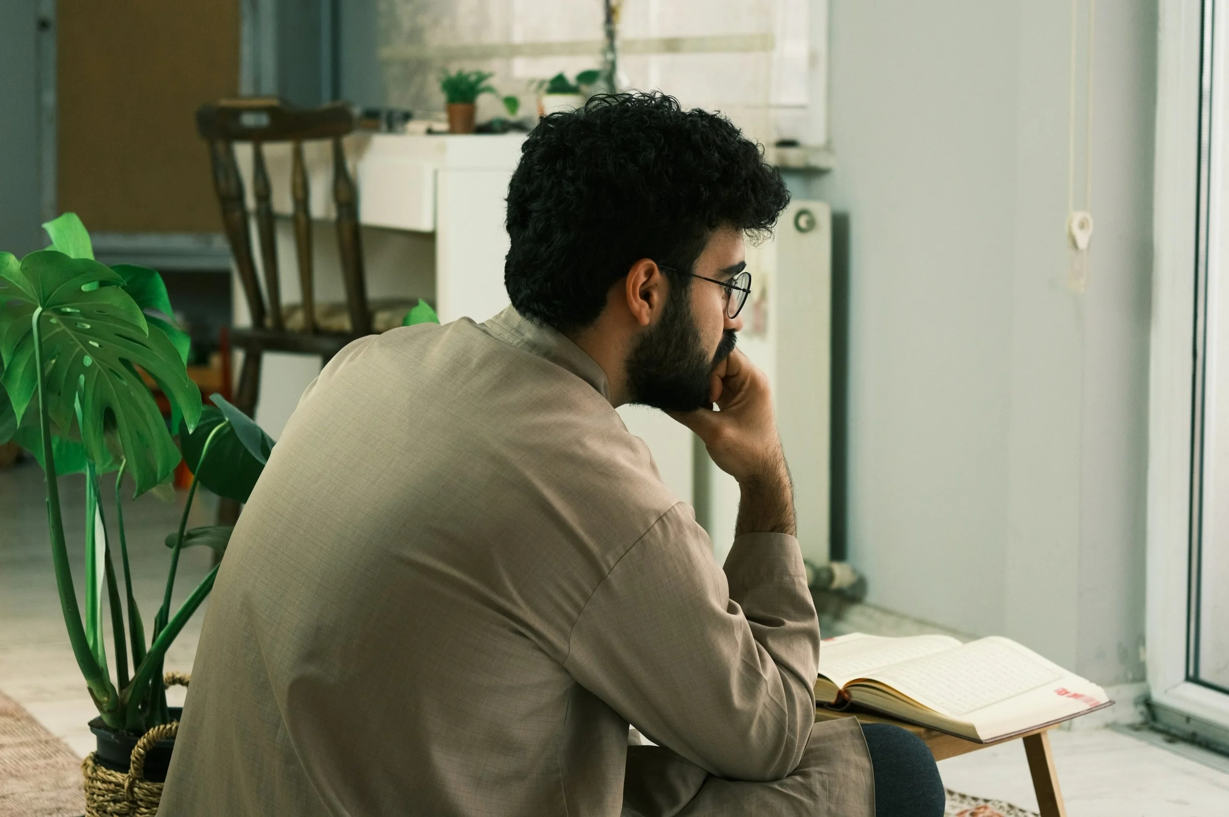 Thoughtful person sitting quietly in emotional reflection, representing emotional processing, self-awareness, and reconnecting with feelings instead of intellectualizing them