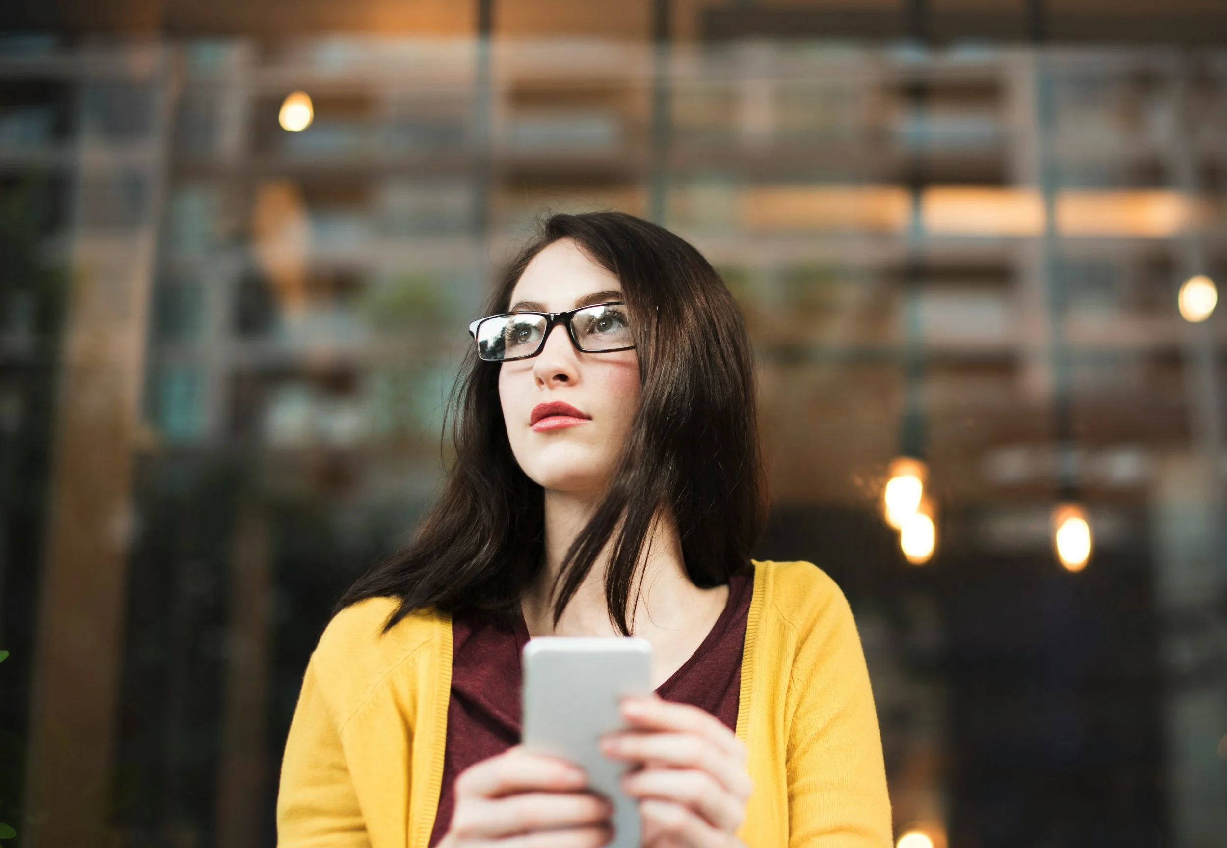 Thoughtful woman looking at her reflection while experiencing appearance-related self-awareness and social comparison connected to mental health and self-worth