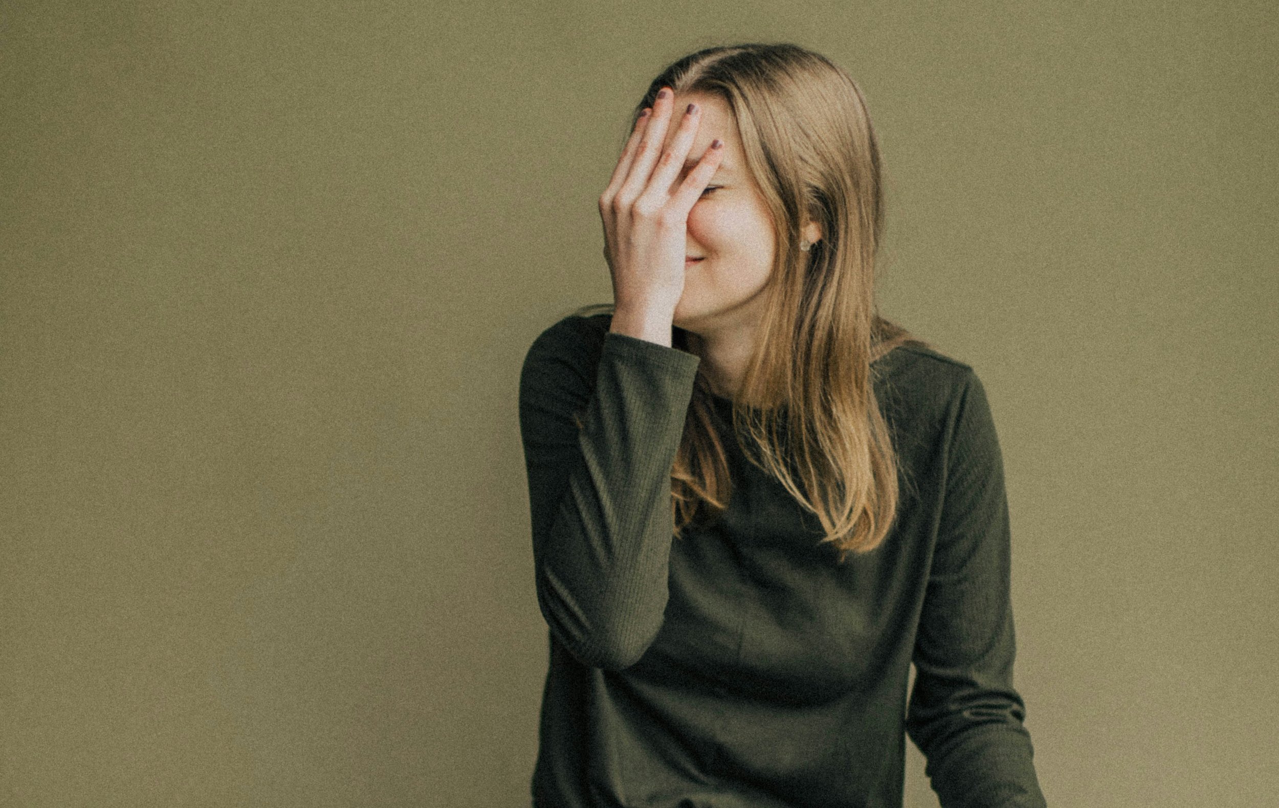 Person sitting alone thinking about conversation and feeling embarrassed