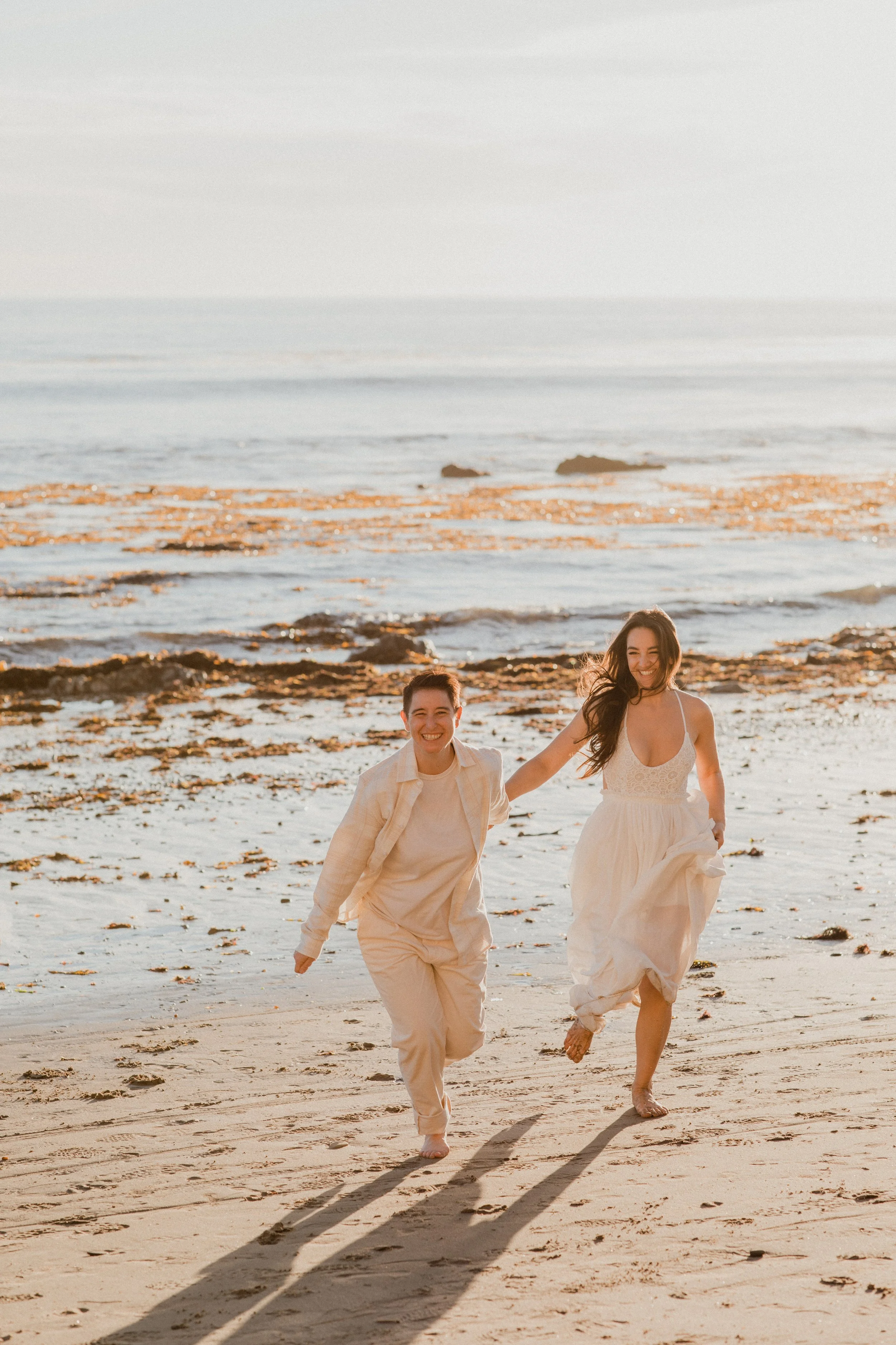 Couple running hand in hand along the beach