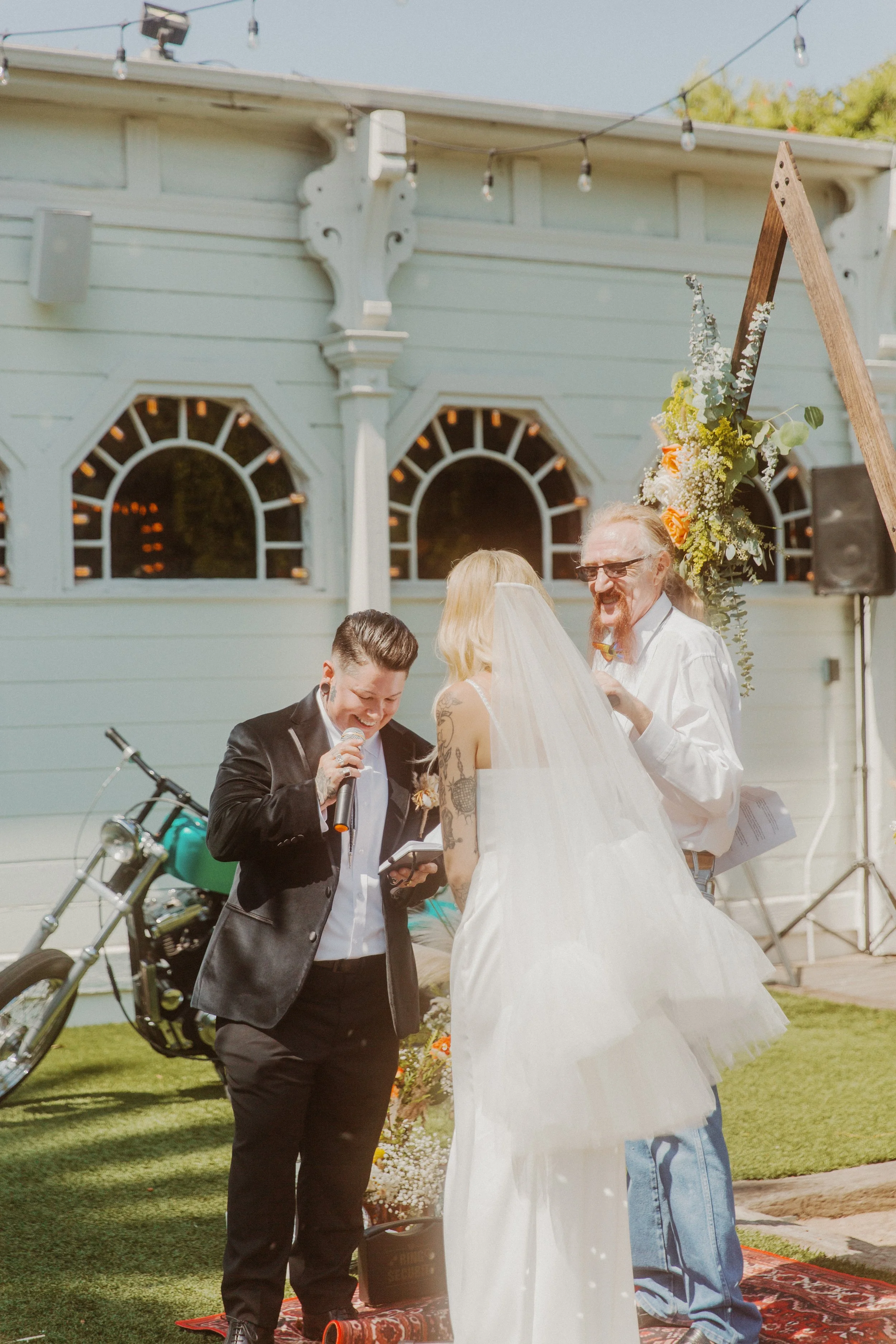 Partner reading vows as the bride and officiant look on