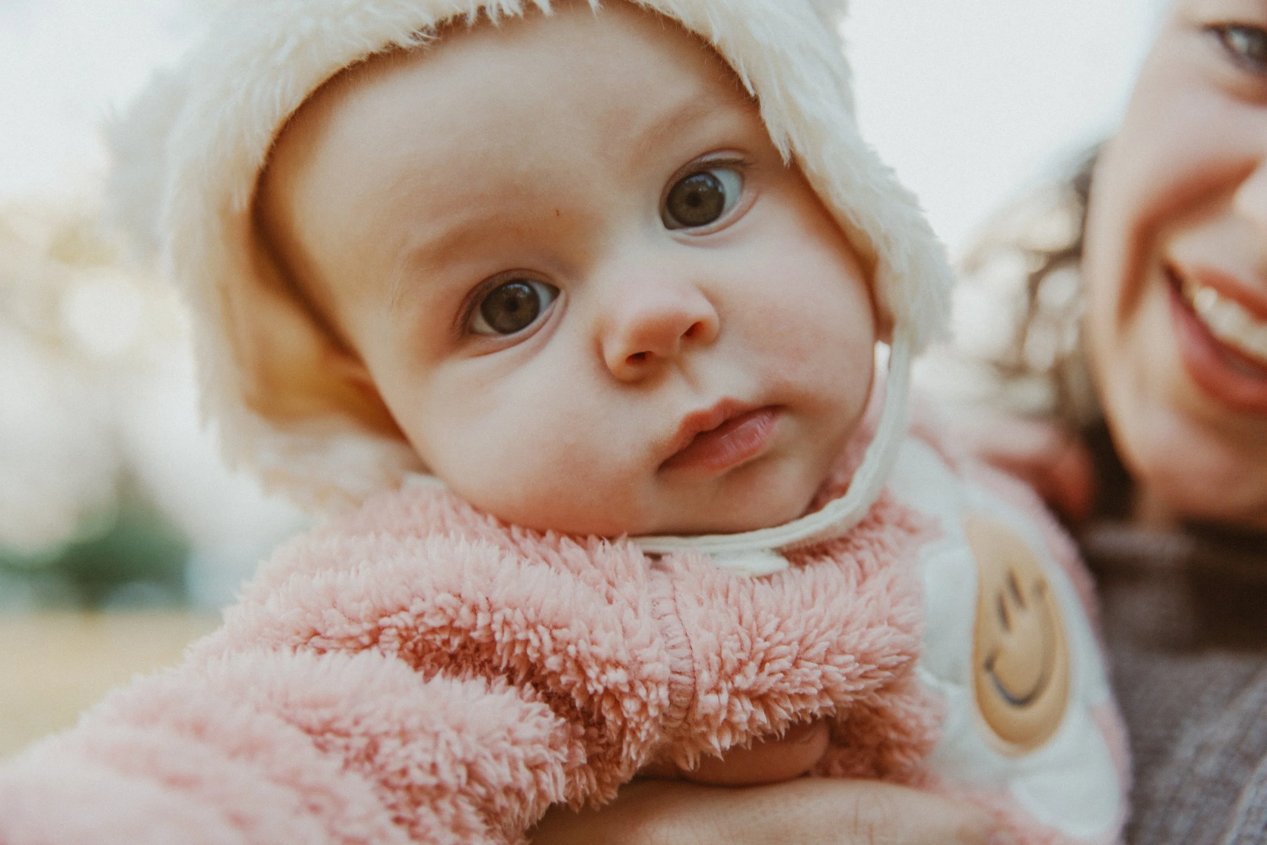 Close-up of a baby in a cozy knit bonnet during a fall family session