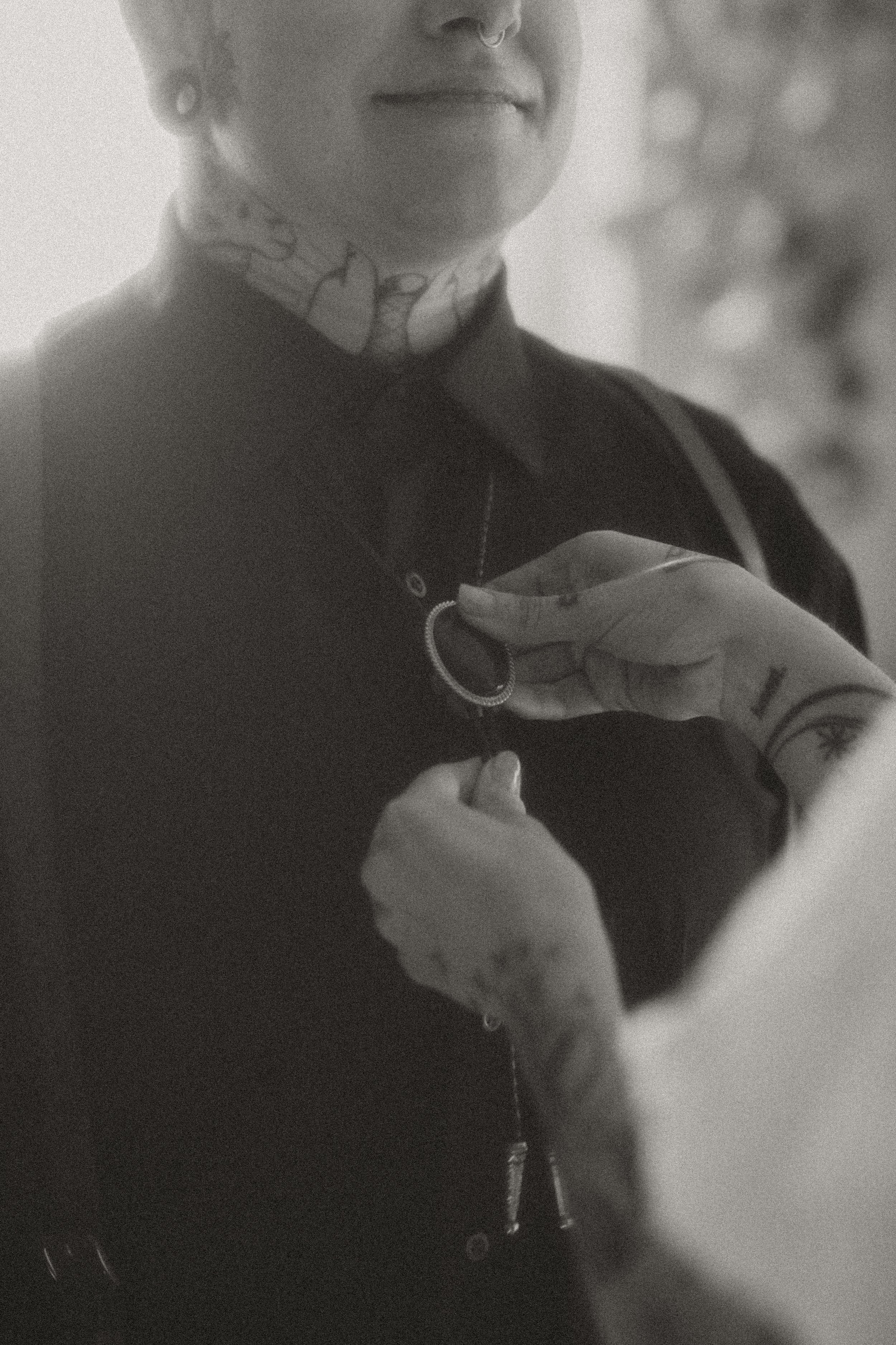 Black and white detail of a groom's boutonniere being pinned on