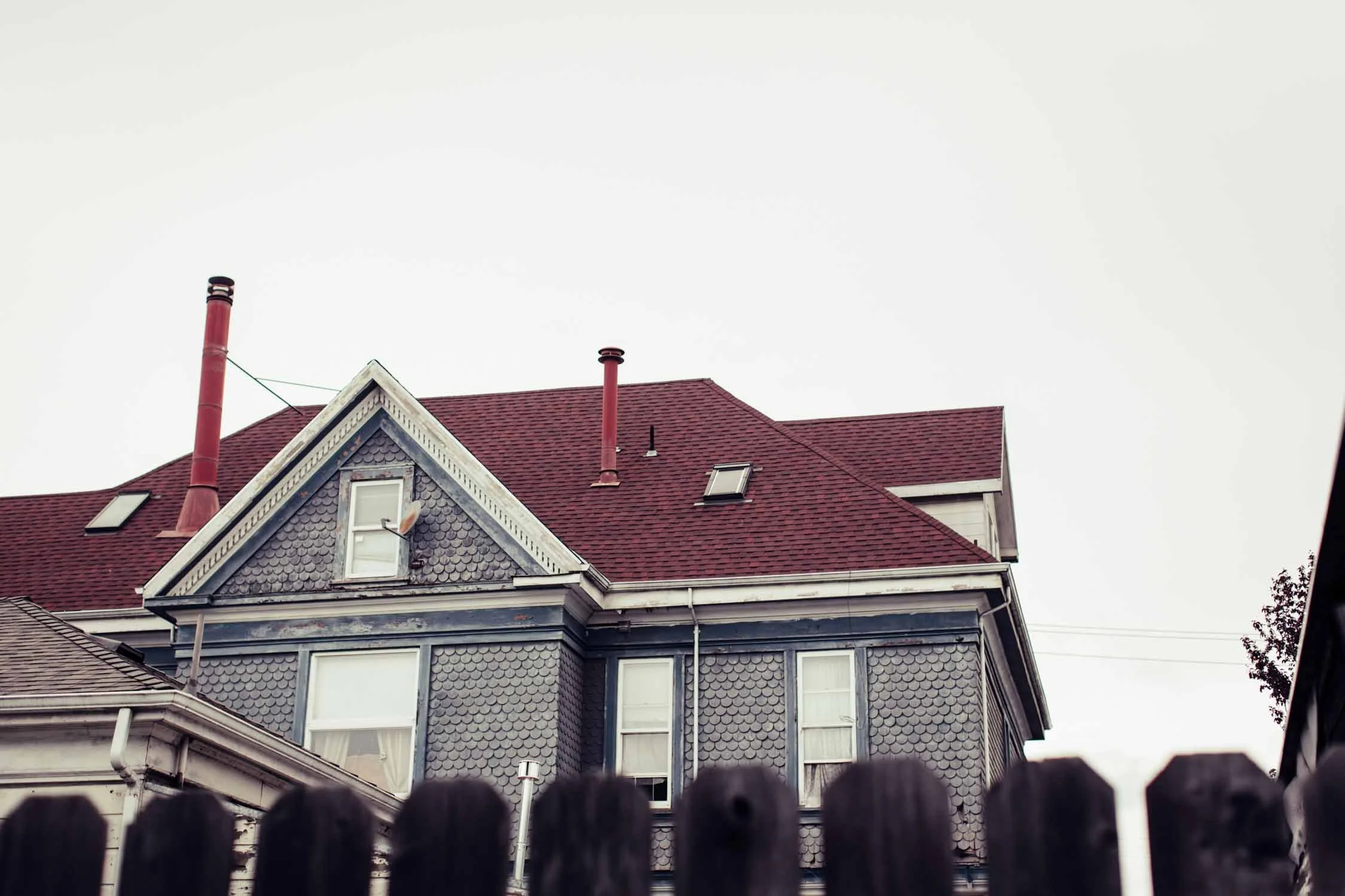 Blue Victorian house with a red roof, the setting of an in-home couples session