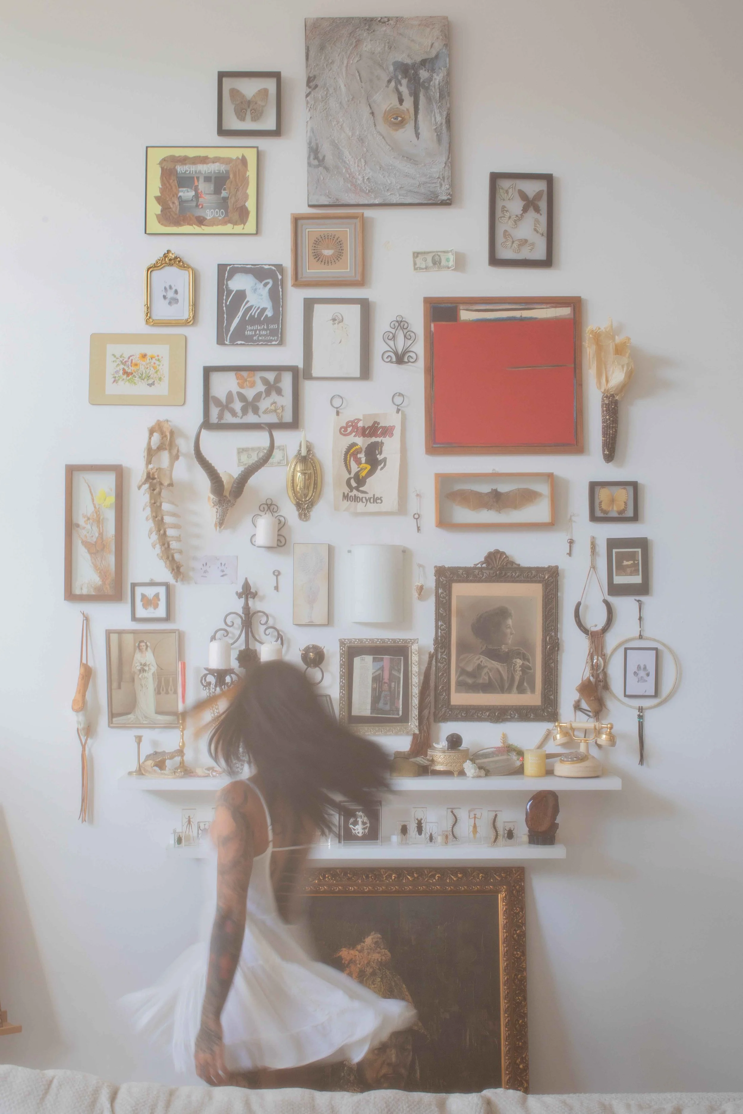 Woman twirling in front of a gallery wall of framed art