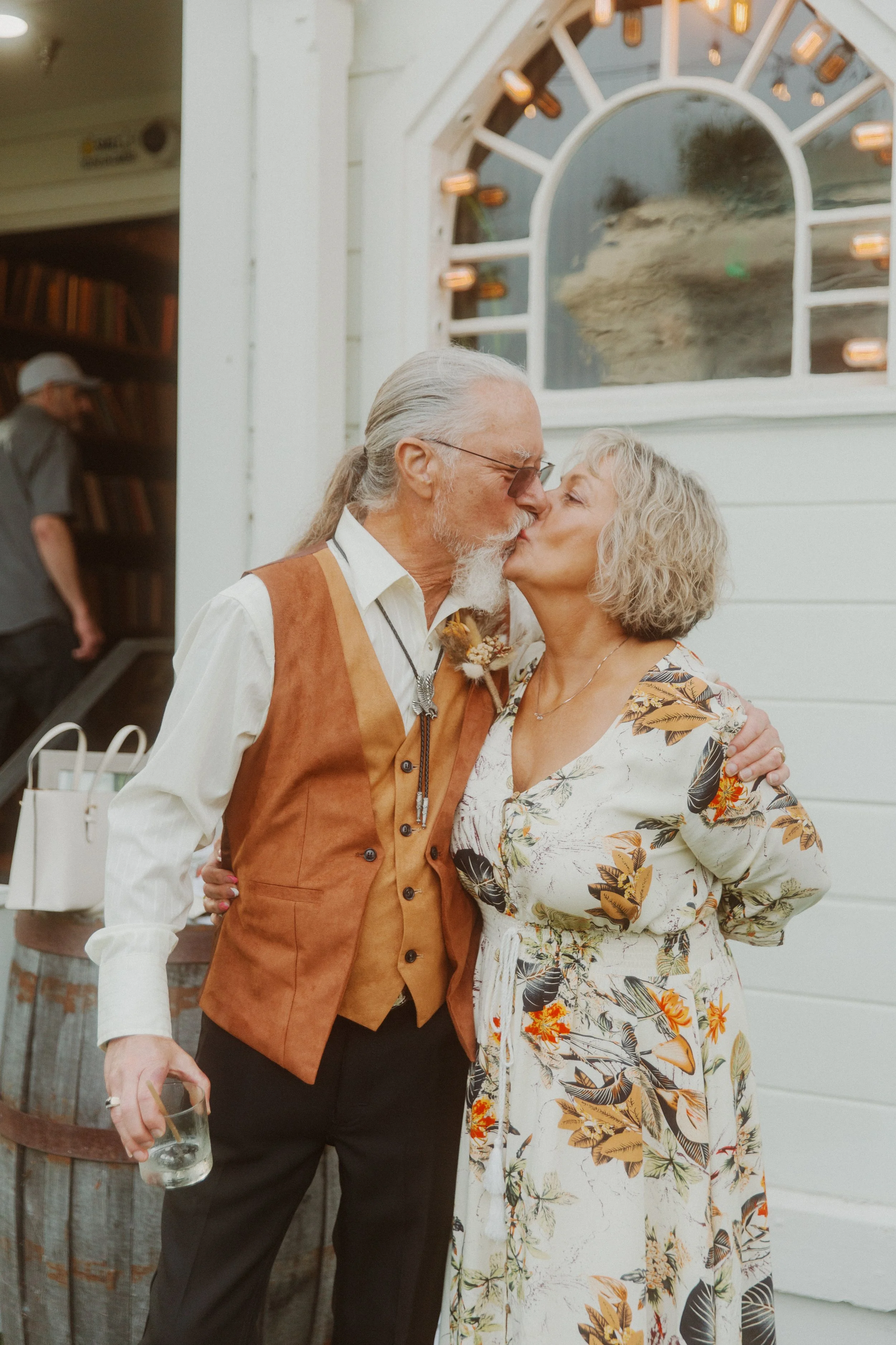 Older couple sharing a kiss outside a wedding reception