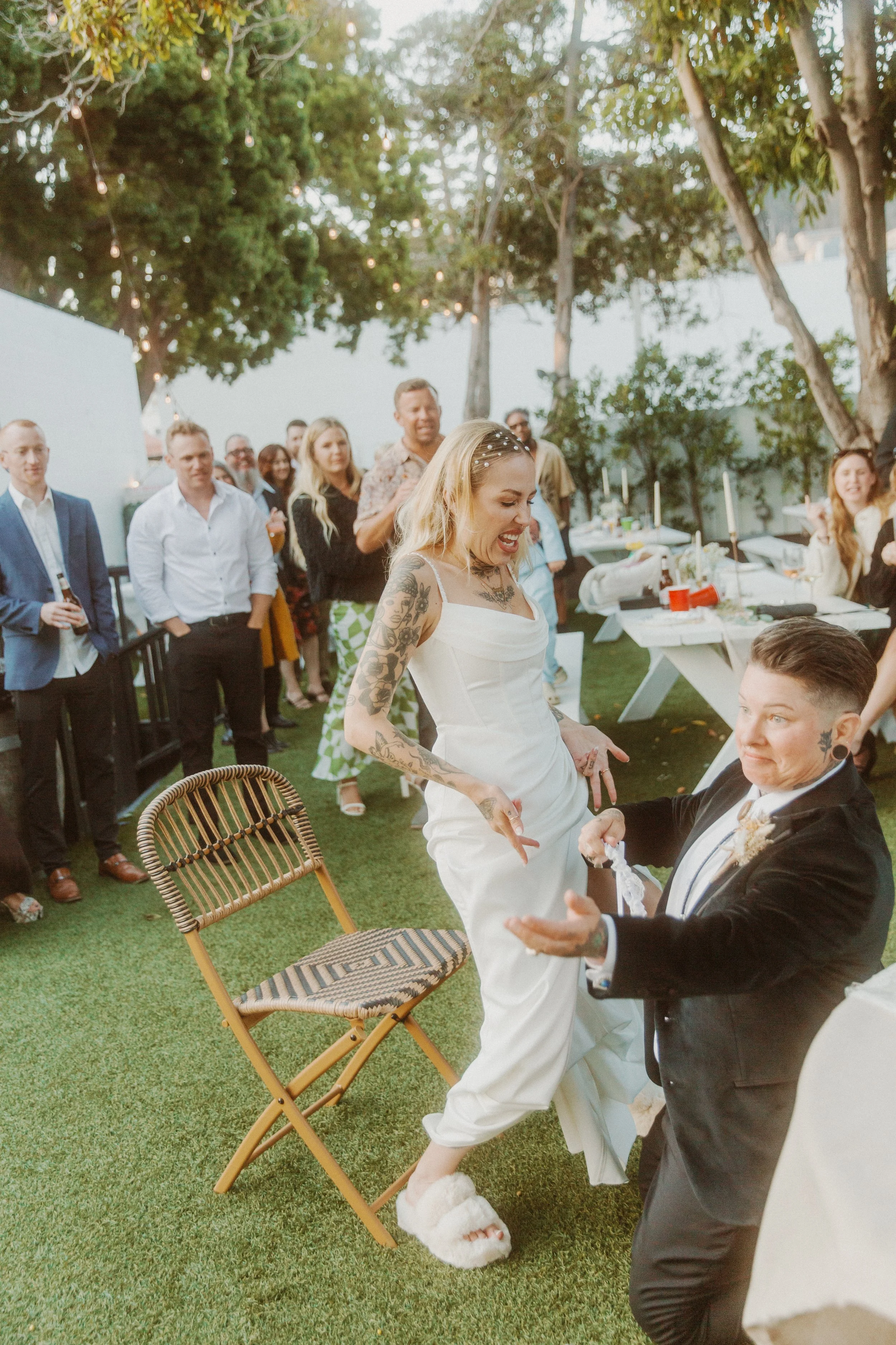 Newlyweds dancing on the lawn as guests look on