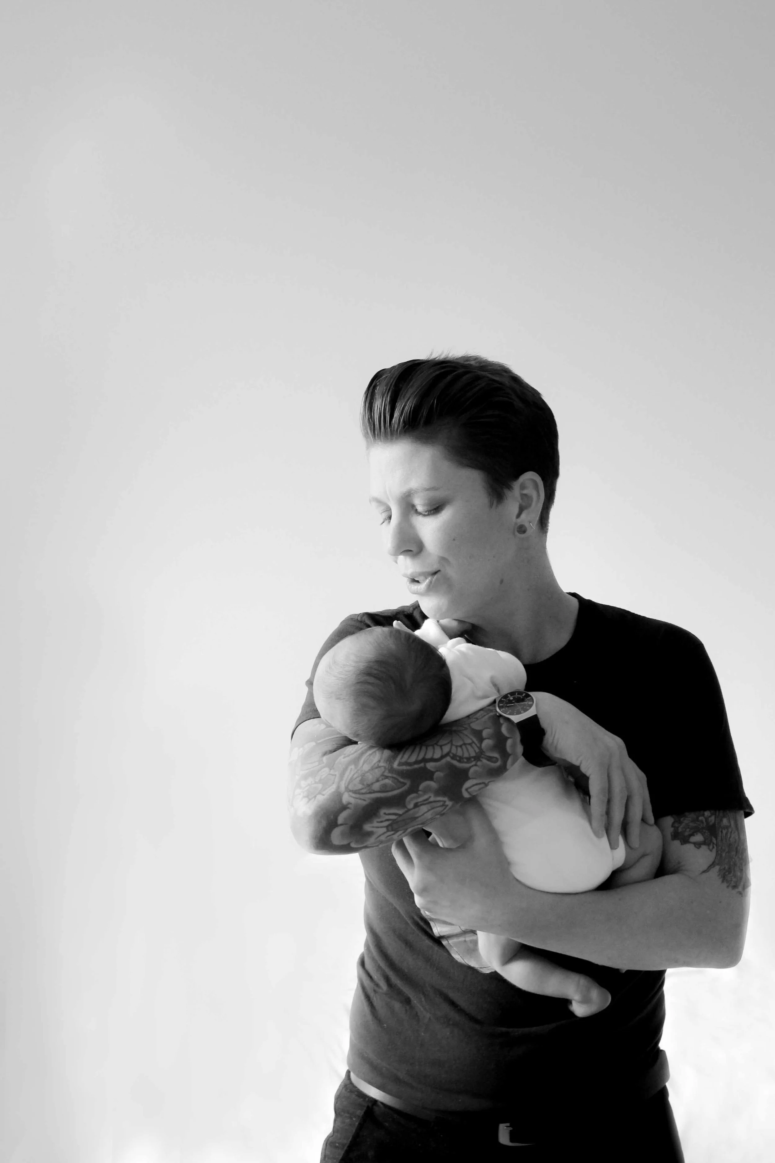 Black and white portrait of a parent cradling their newborn