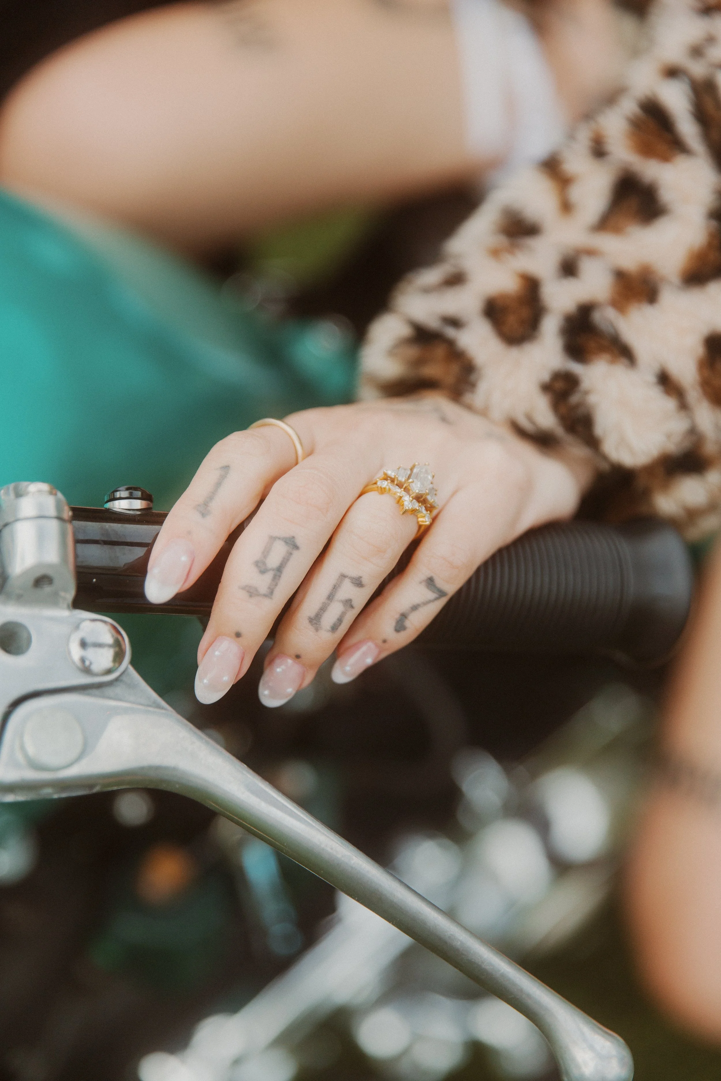 Close-up of a hand wearing a wedding ring on a motorcycle handlebar