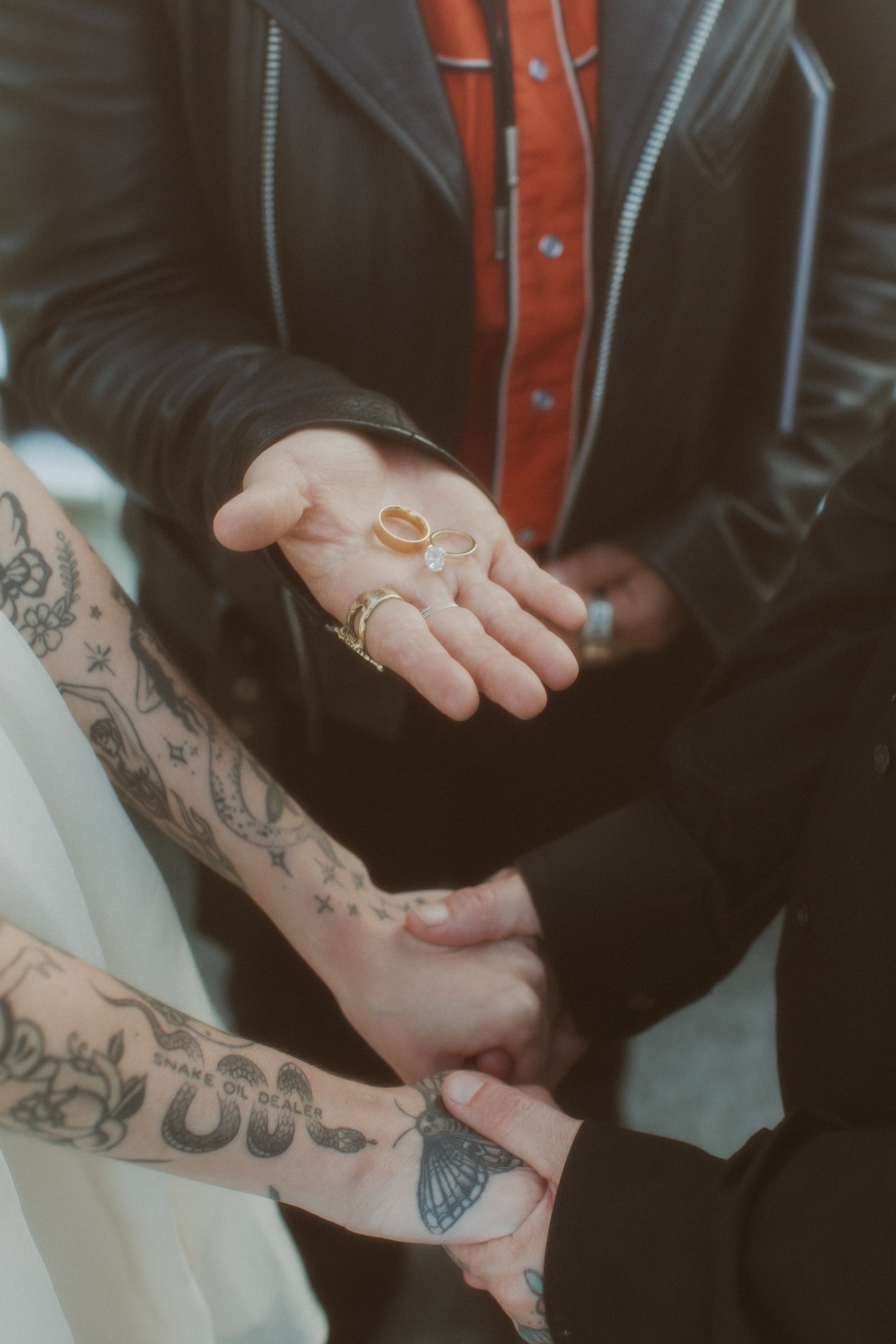 Tattooed couple exchanging rings during their elopement ceremony