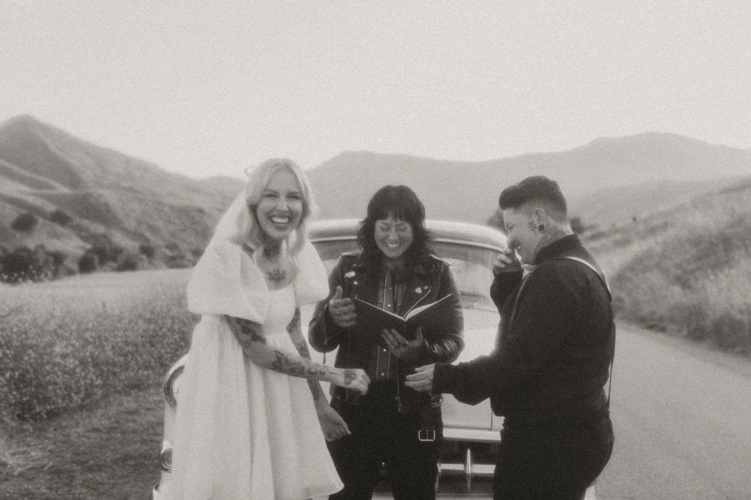 Couple and officiant during an intimate hillside elopement ceremony