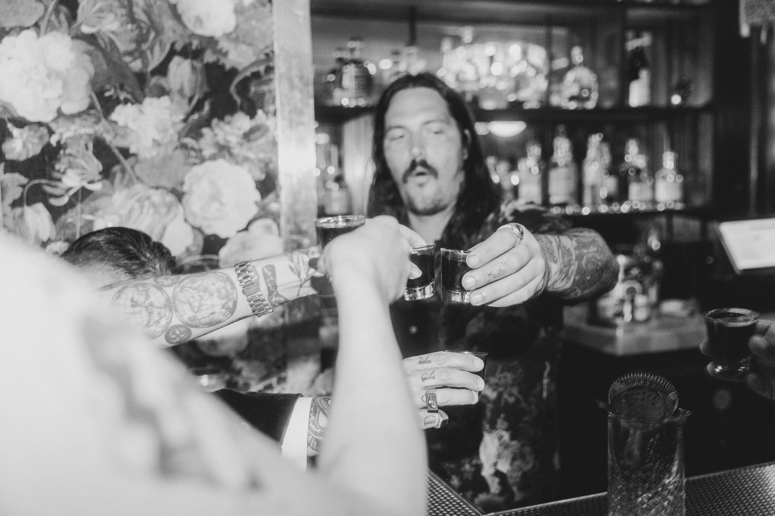 Black and white photo of a bartender pouring a drink at a wedding reception