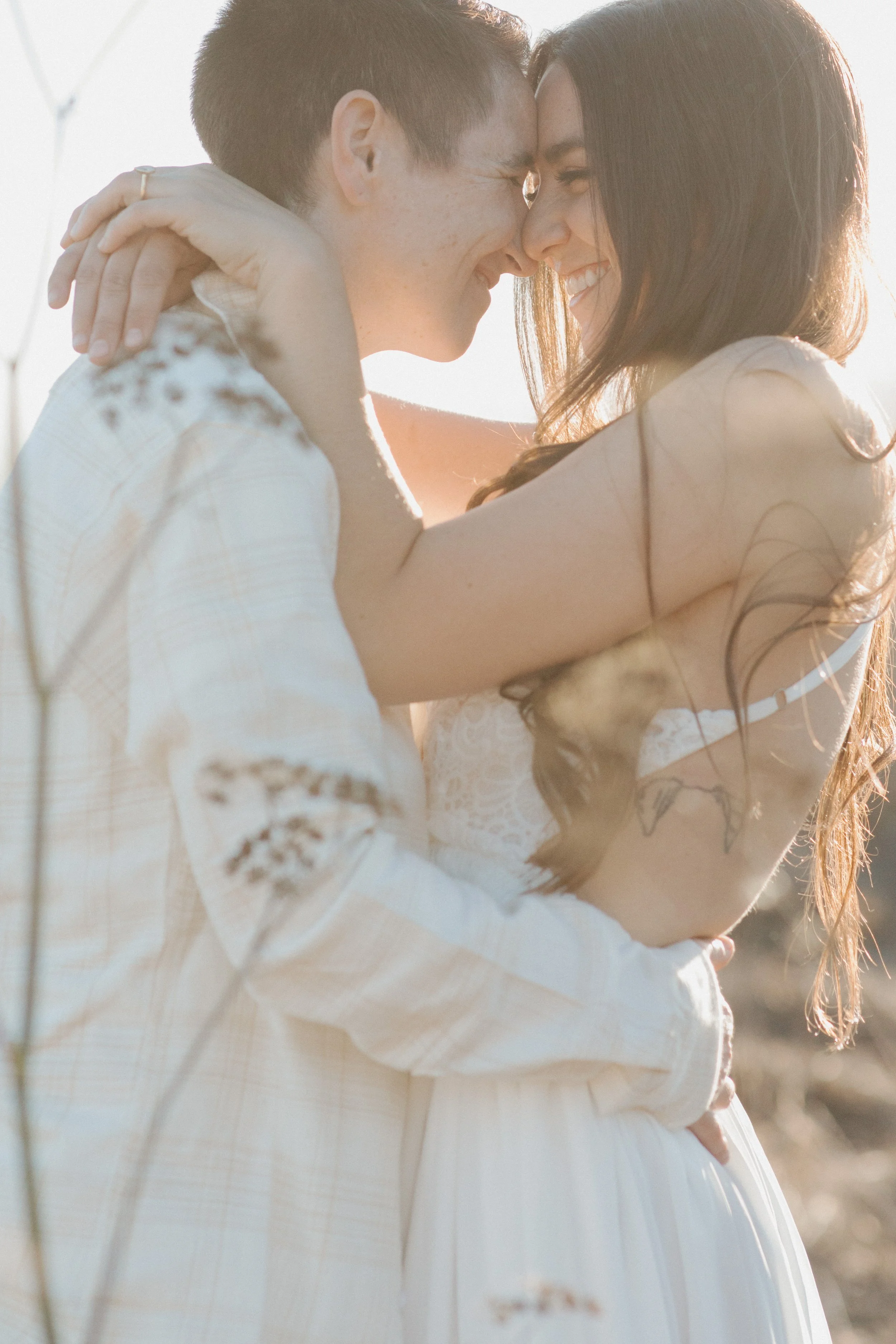 Couple embracing forehead to forehead in warm golden light