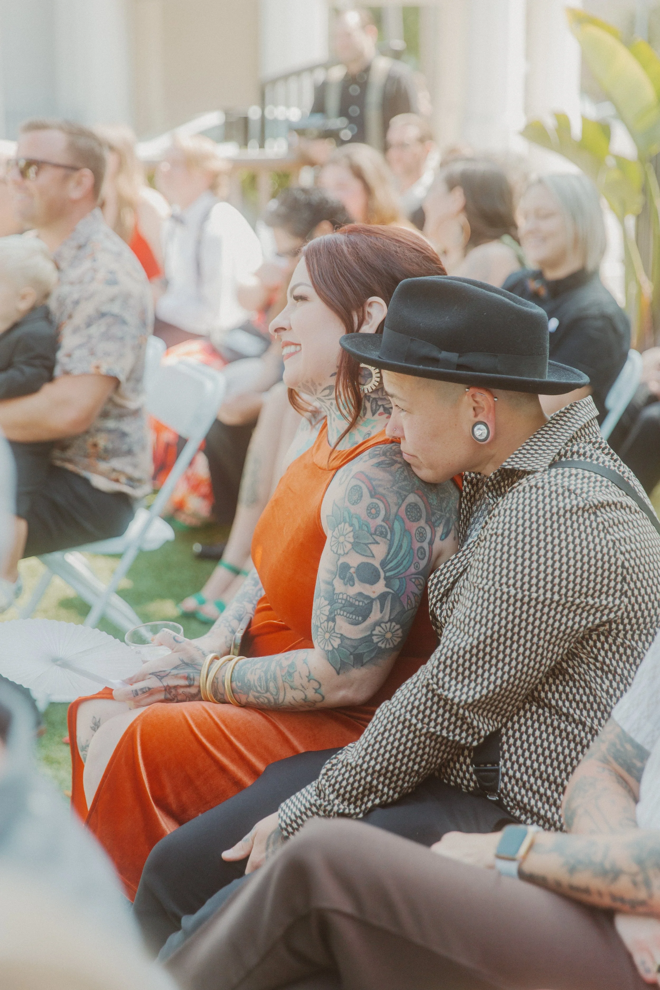 Wedding guests smiling as they watch the ceremony