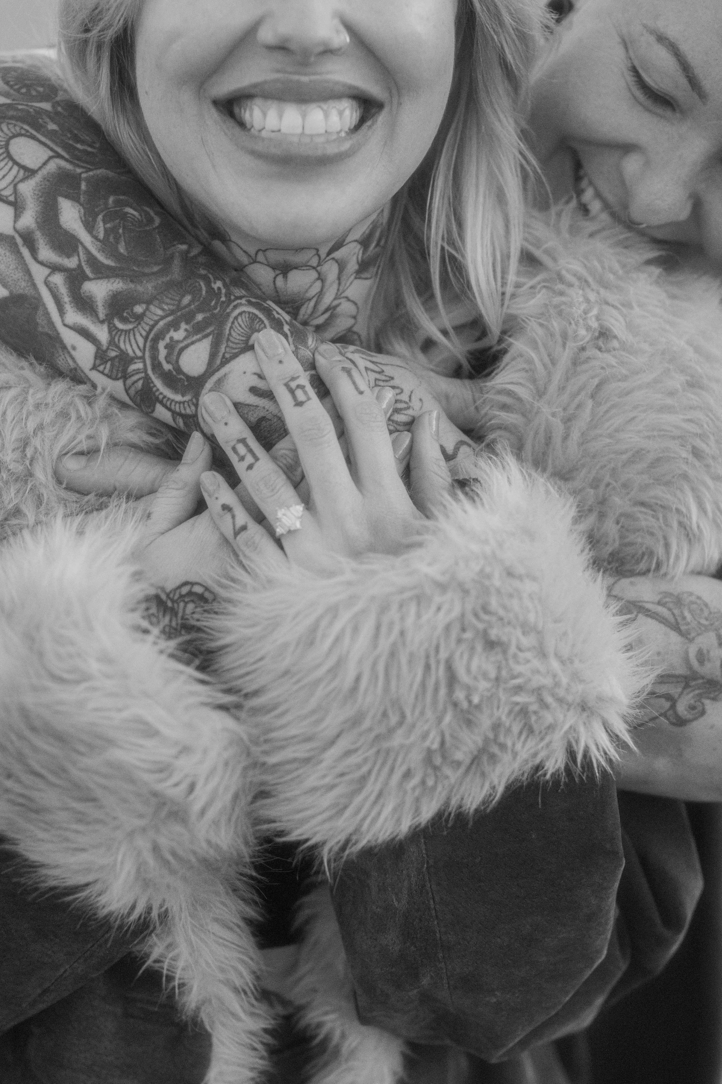Couple laughing close together in cozy coats after a surprise proposal