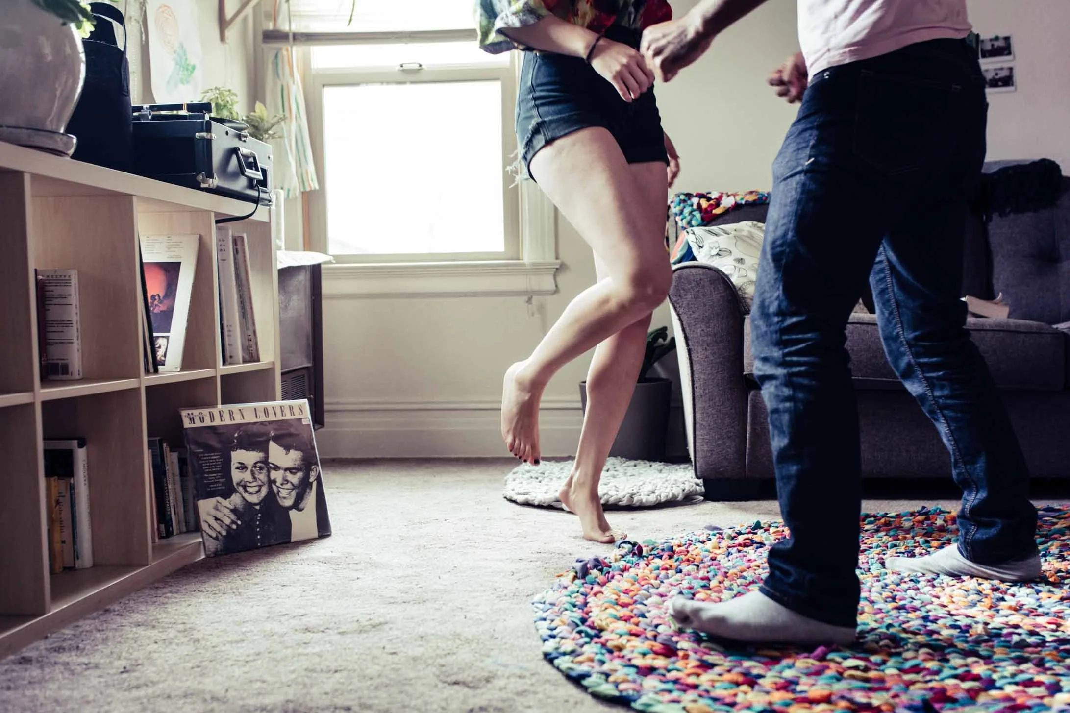 Couple dancing barefoot in their living room during an in-home session