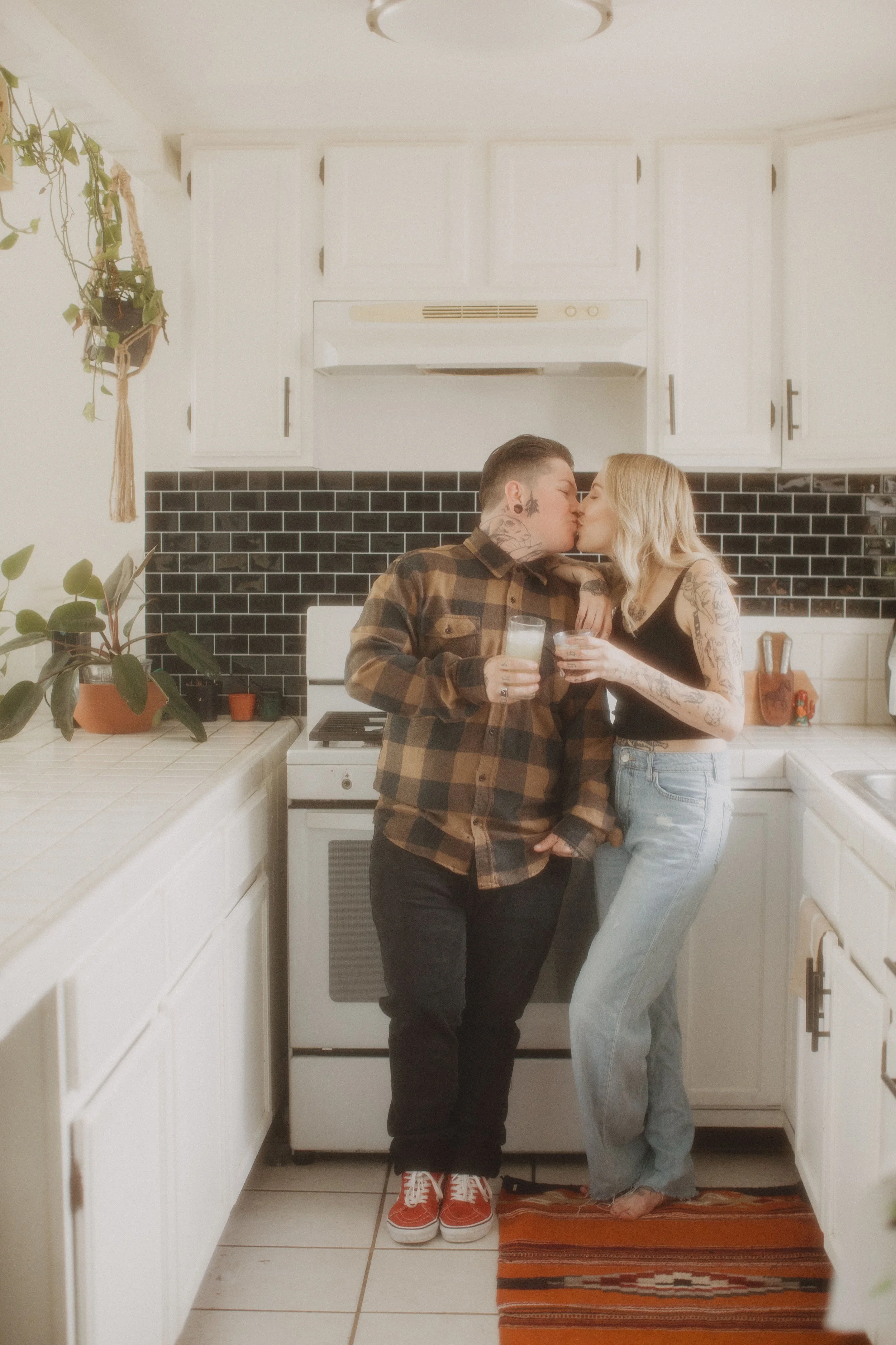 Couple embracing in a bright retro kitchen on their elopement day