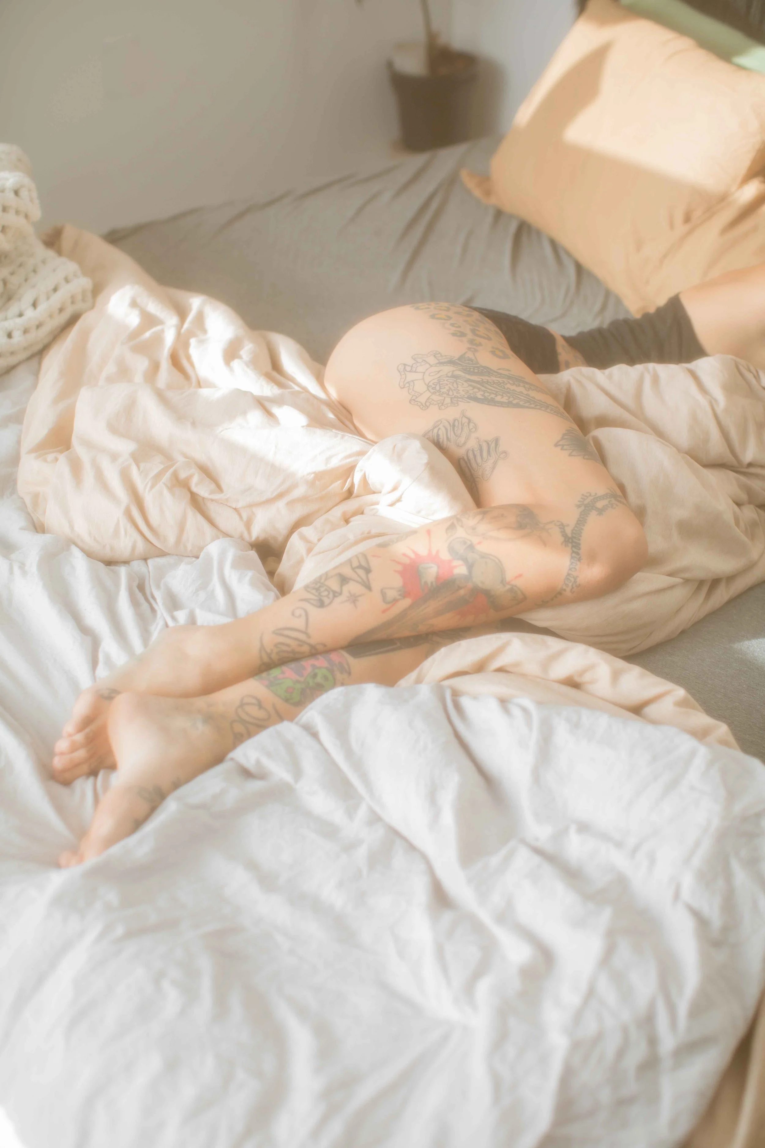 Relaxed at-home lifestyle portrait of a woman lounging on soft bedding