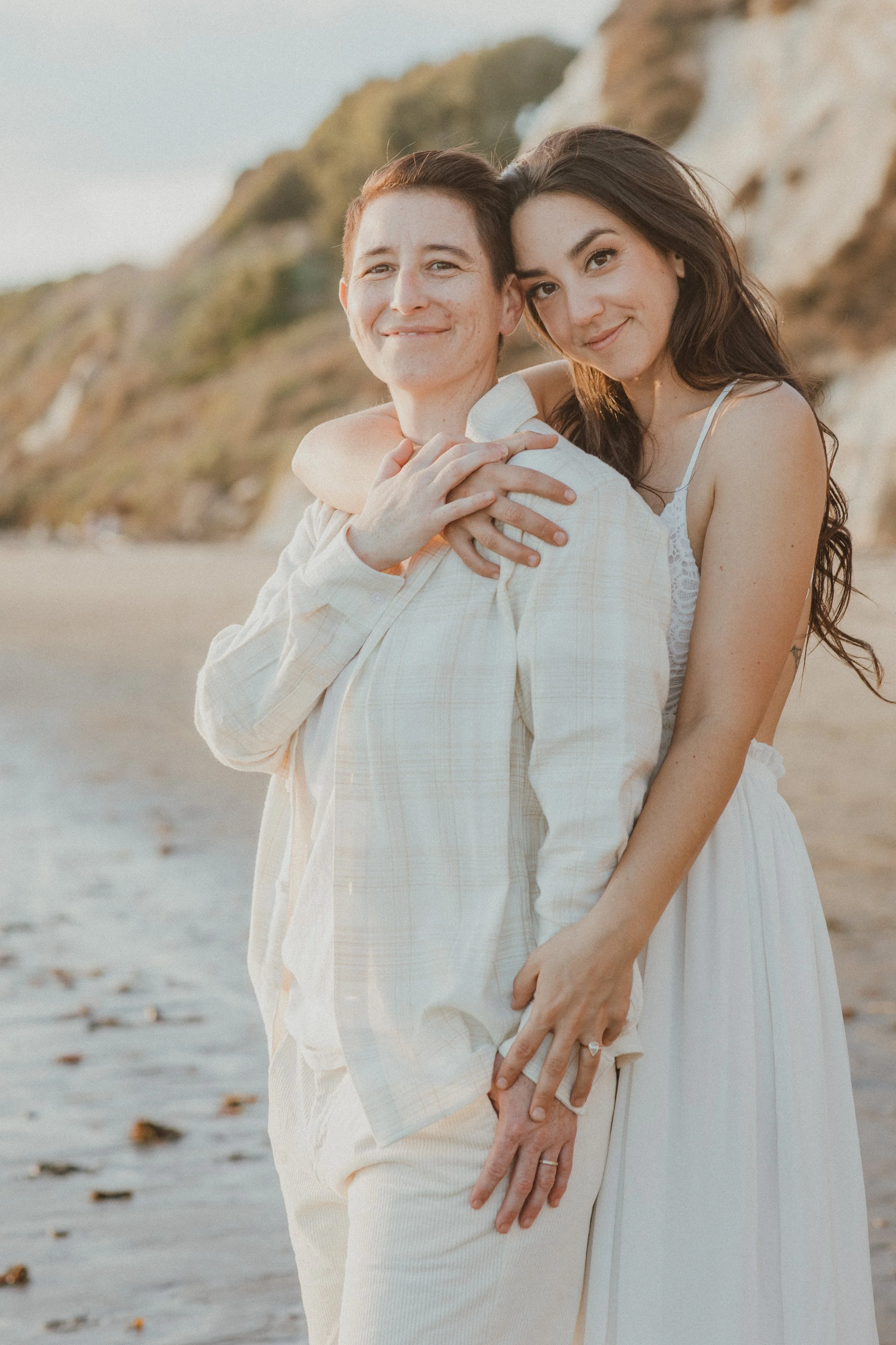 Couple embracing on the beach at golden hour
