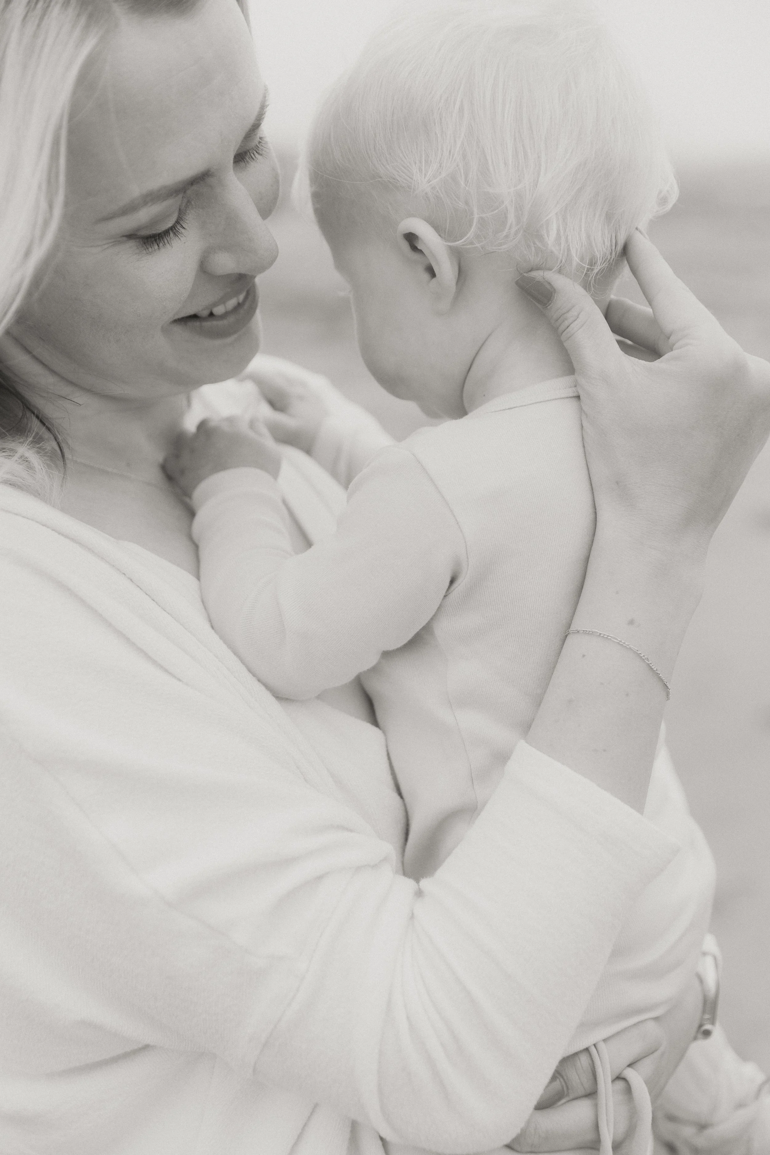 Mother smiling at her baby during a soft, natural family session