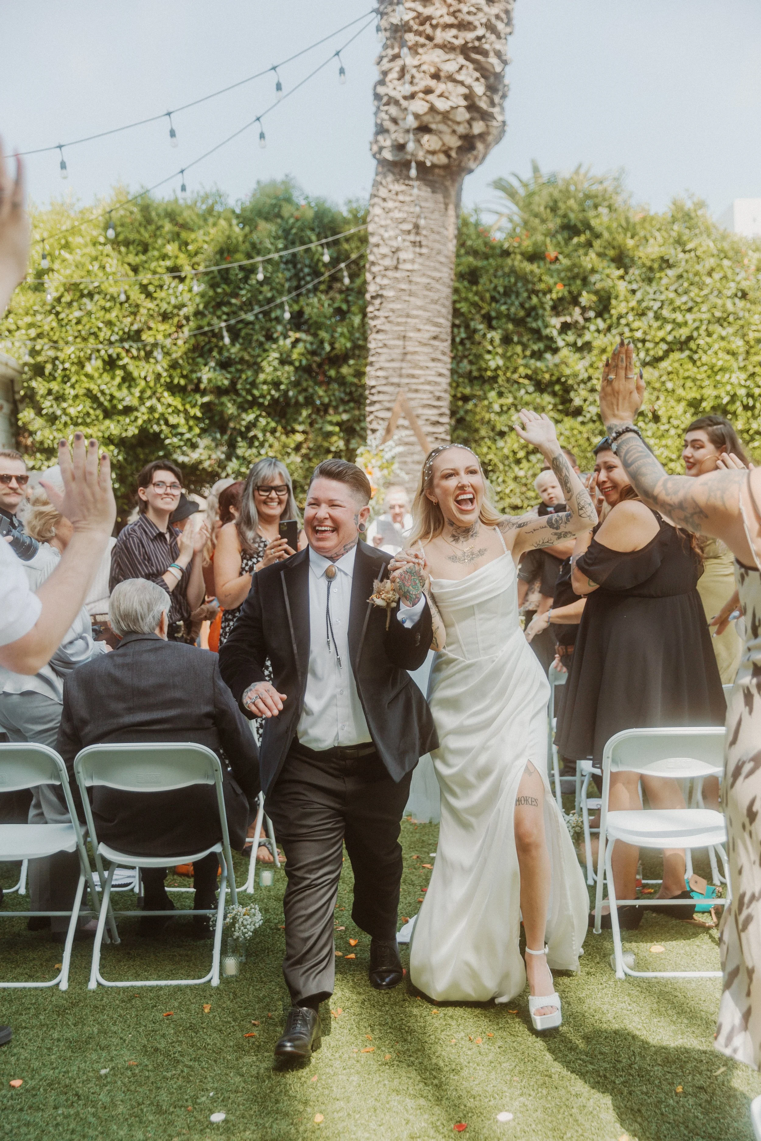 Newlyweds walking back down the aisle as guests cheer