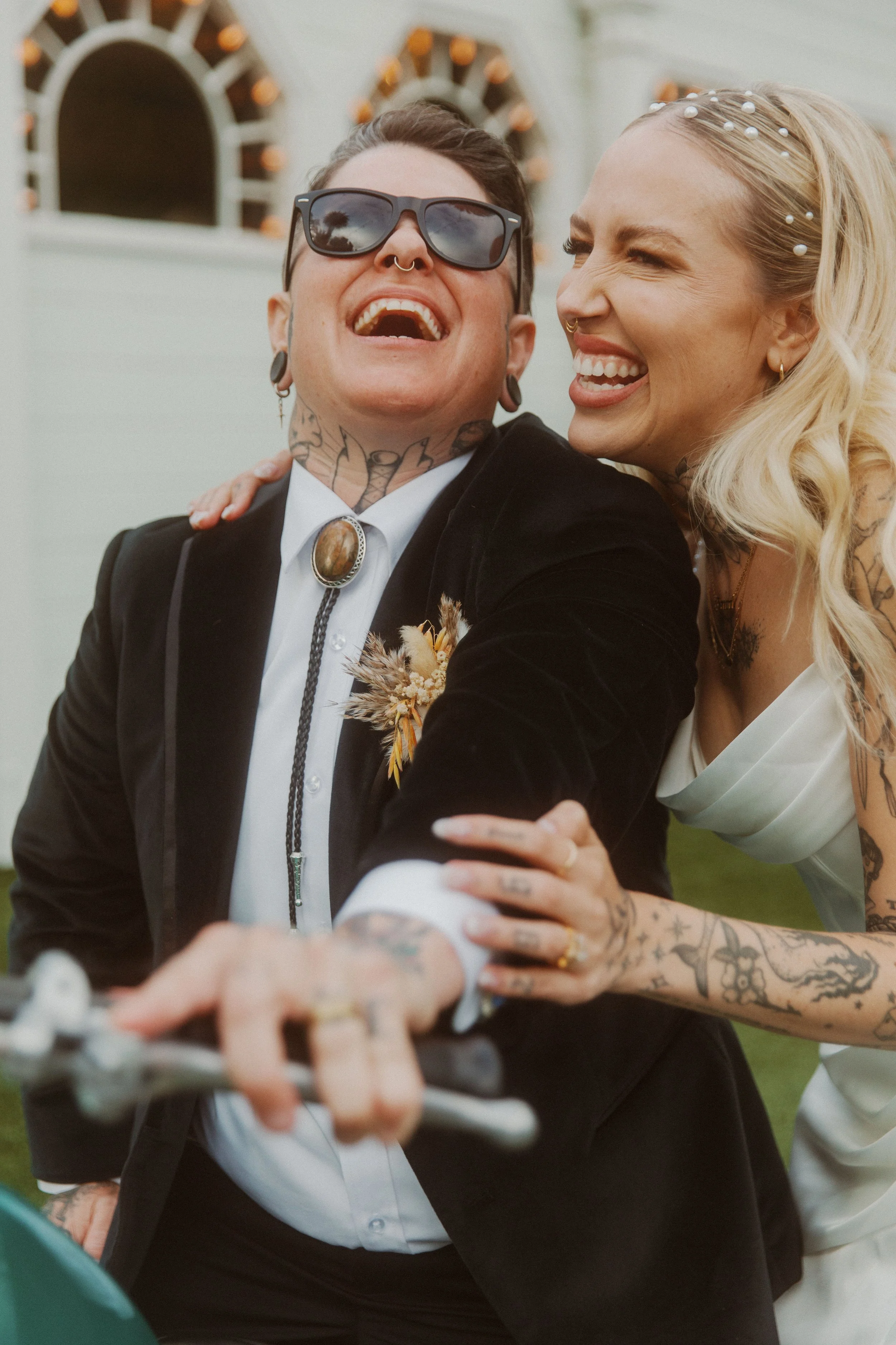 Newlyweds laughing together on a motorcycle