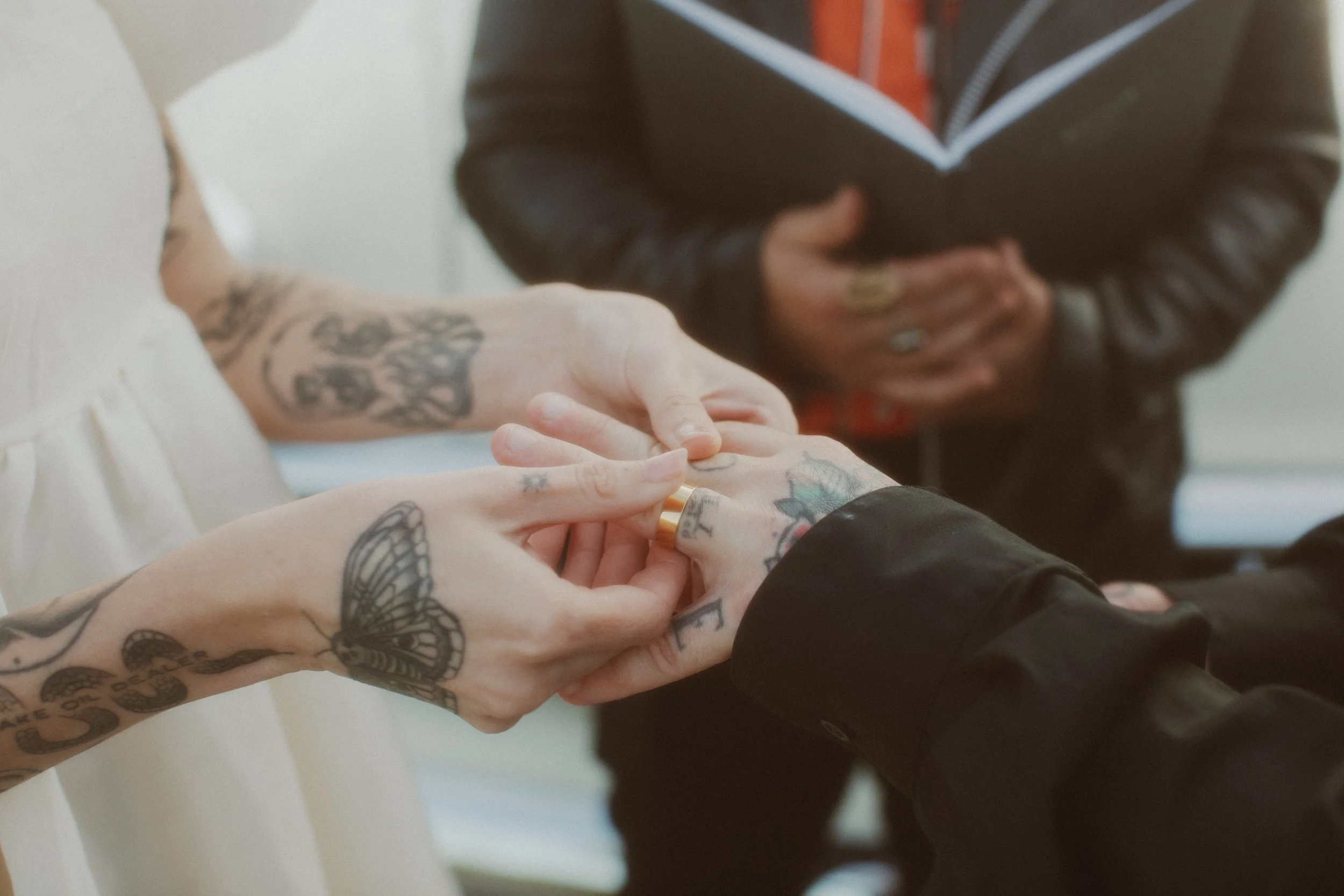 Couple holding hands and exchanging rings at their elopement