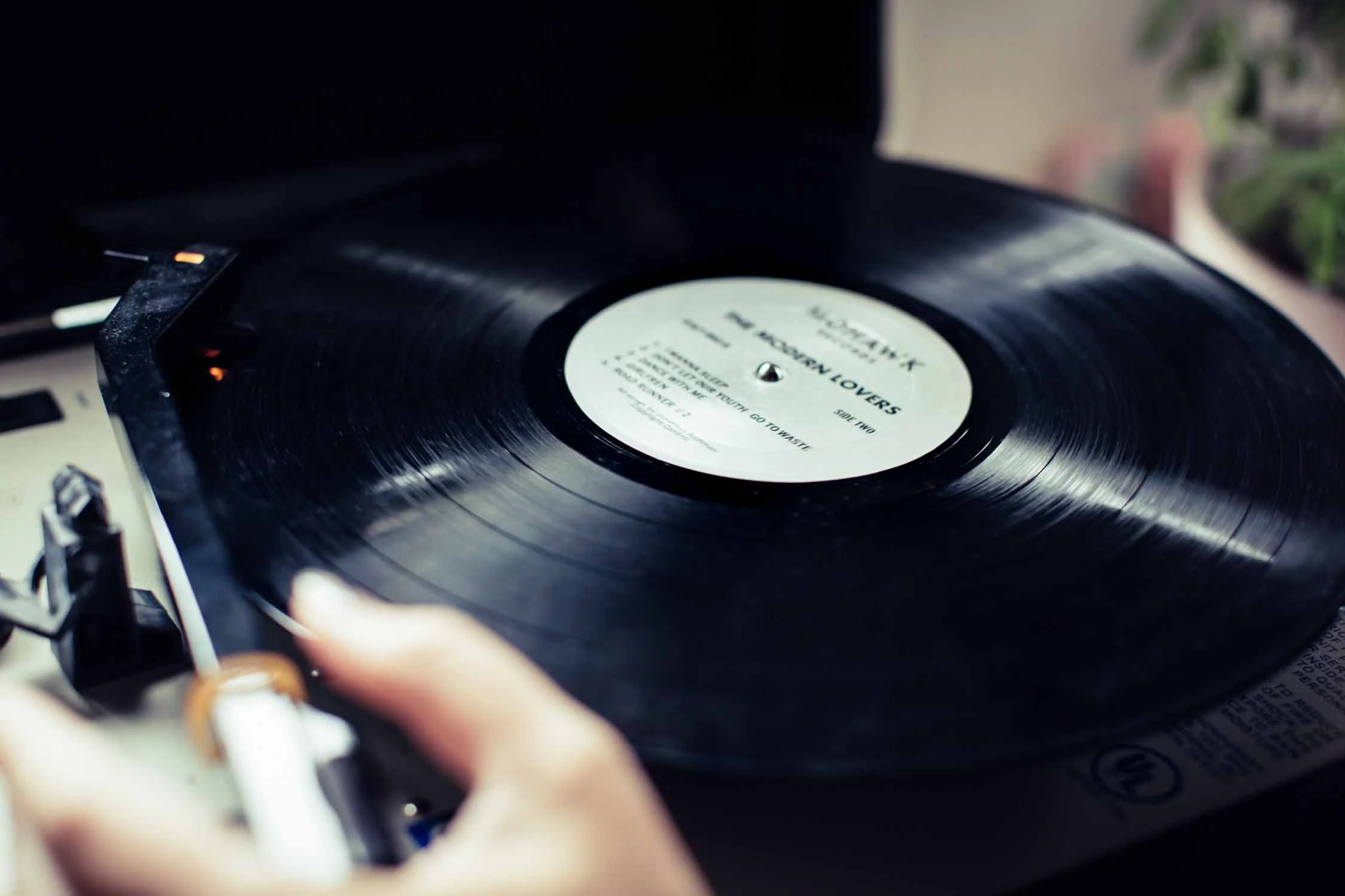 Hand setting a record on a turntable during an at-home couples session