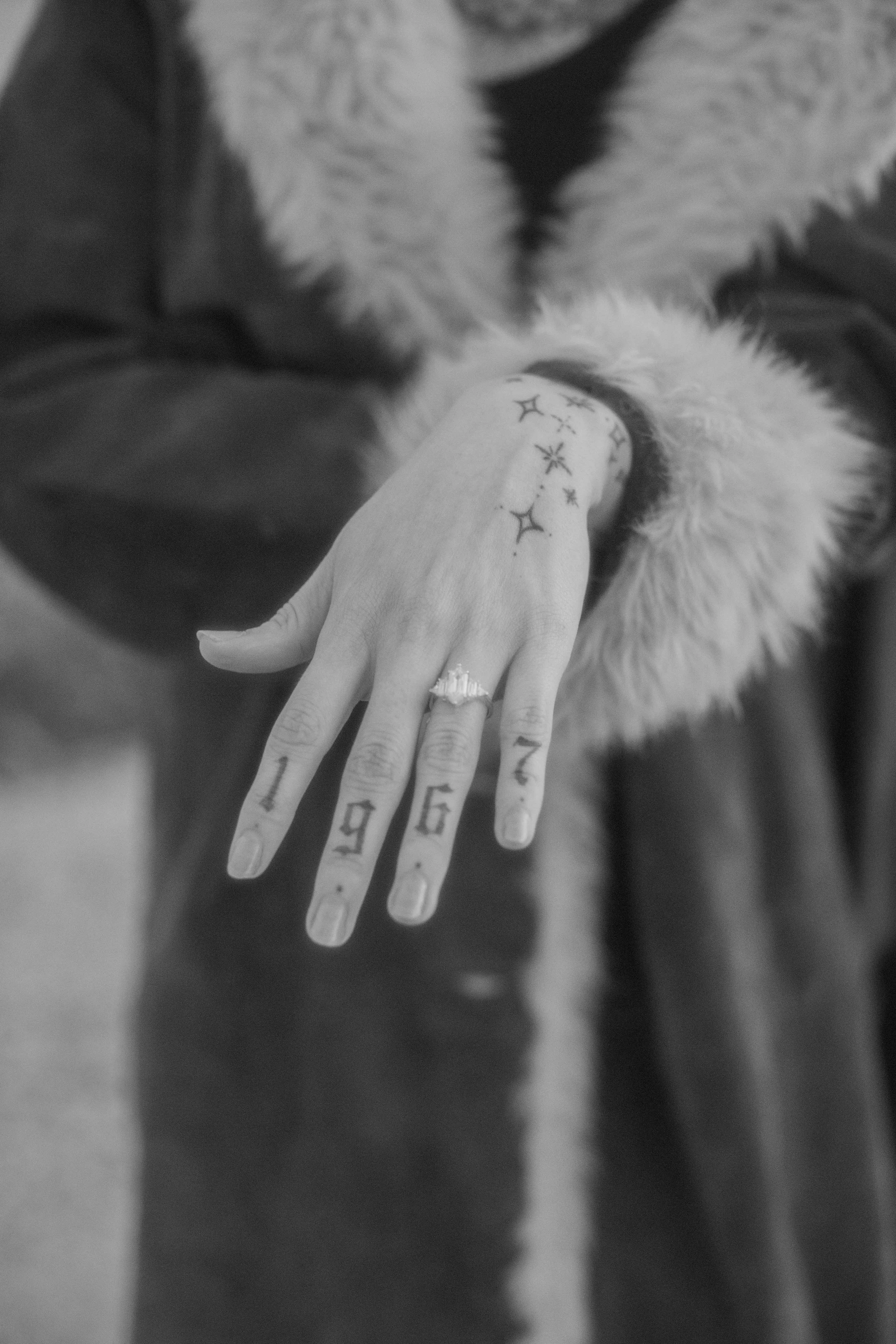 Close-up of a new engagement ring on a tattooed hand
