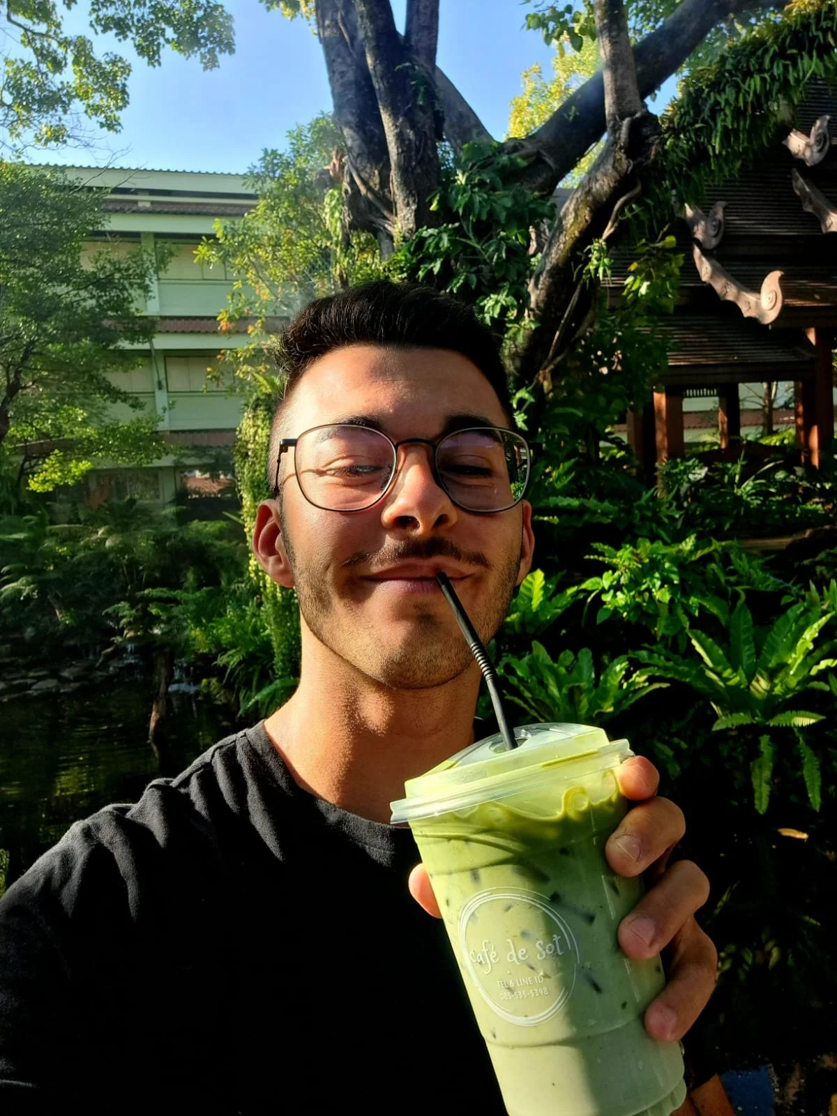 Philipp Zimmermann, Webdesigner aus Schaffhausen, trinkt einen Matcha Latte in einer grünen Umgebung.