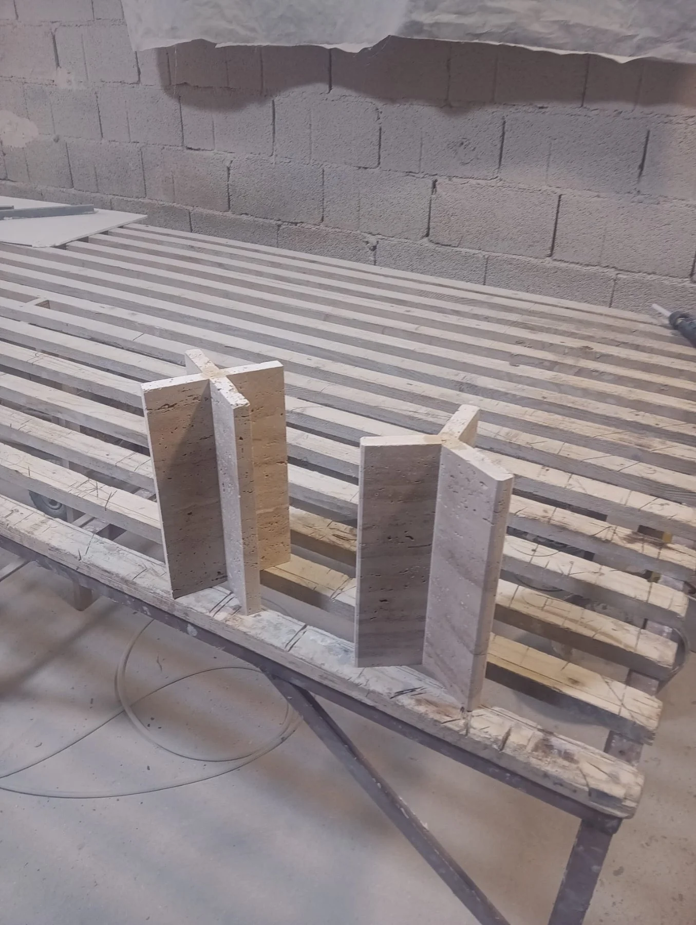 "Raw travertine stone frame in production at the Ebba Design workshop, early stage of a handcrafted lamp base"