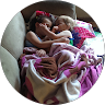 A baby lying on a bed with blankets and stuffed animals.