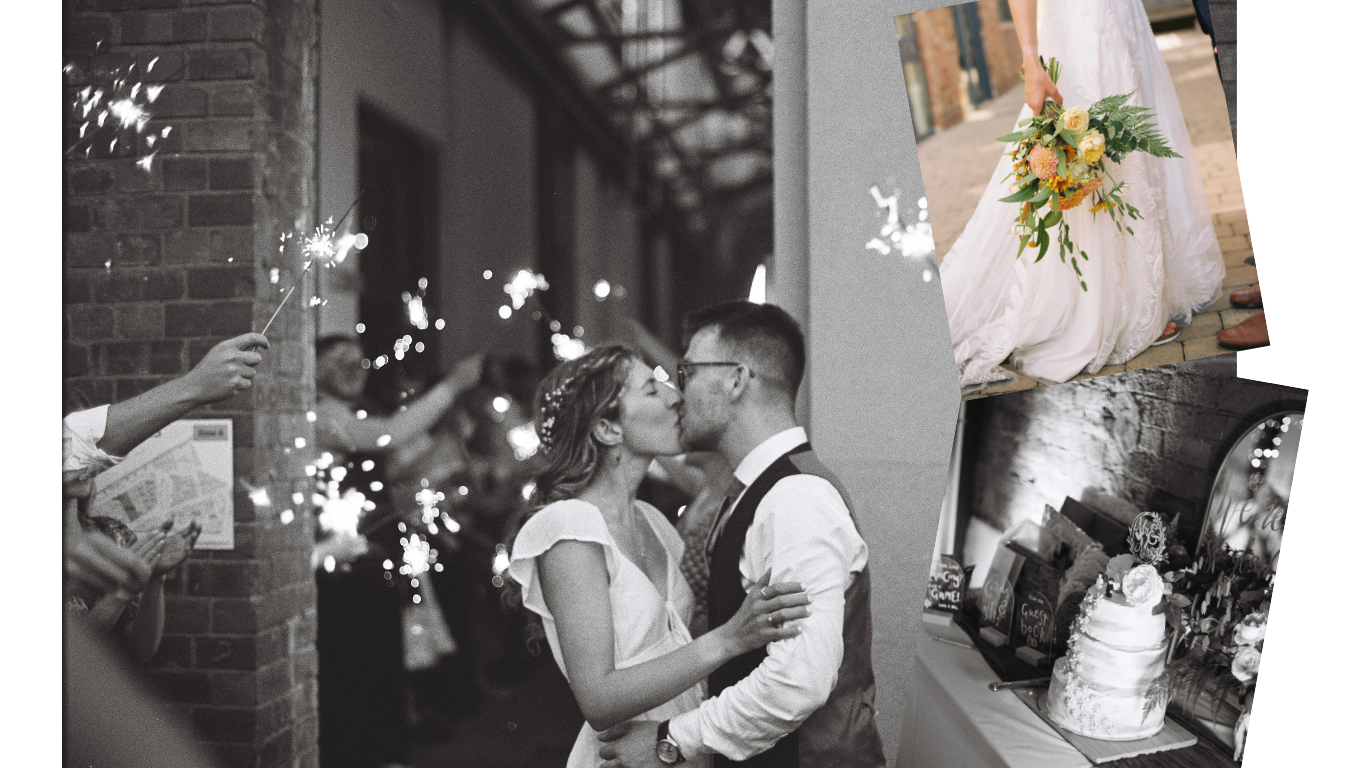 Couple sharing a kiss at their wedding reception, surrounded by sparklers and guests, with a bakery-themed cake decorated with flowers.