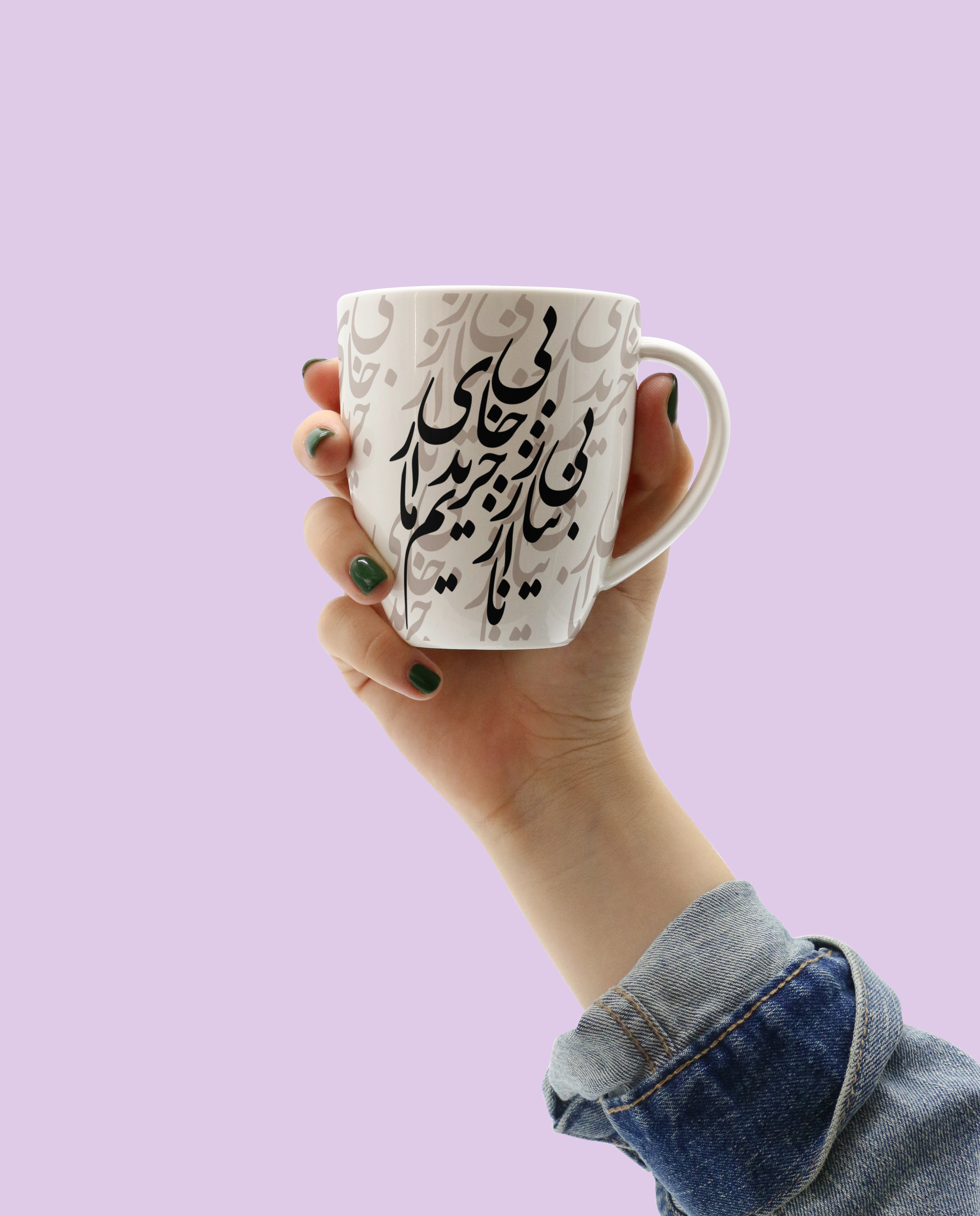 A person wearing a gray denim jacket with yellow stitching holding a white ceramic mug with black Persian calligraphy on it, against a light purple background.