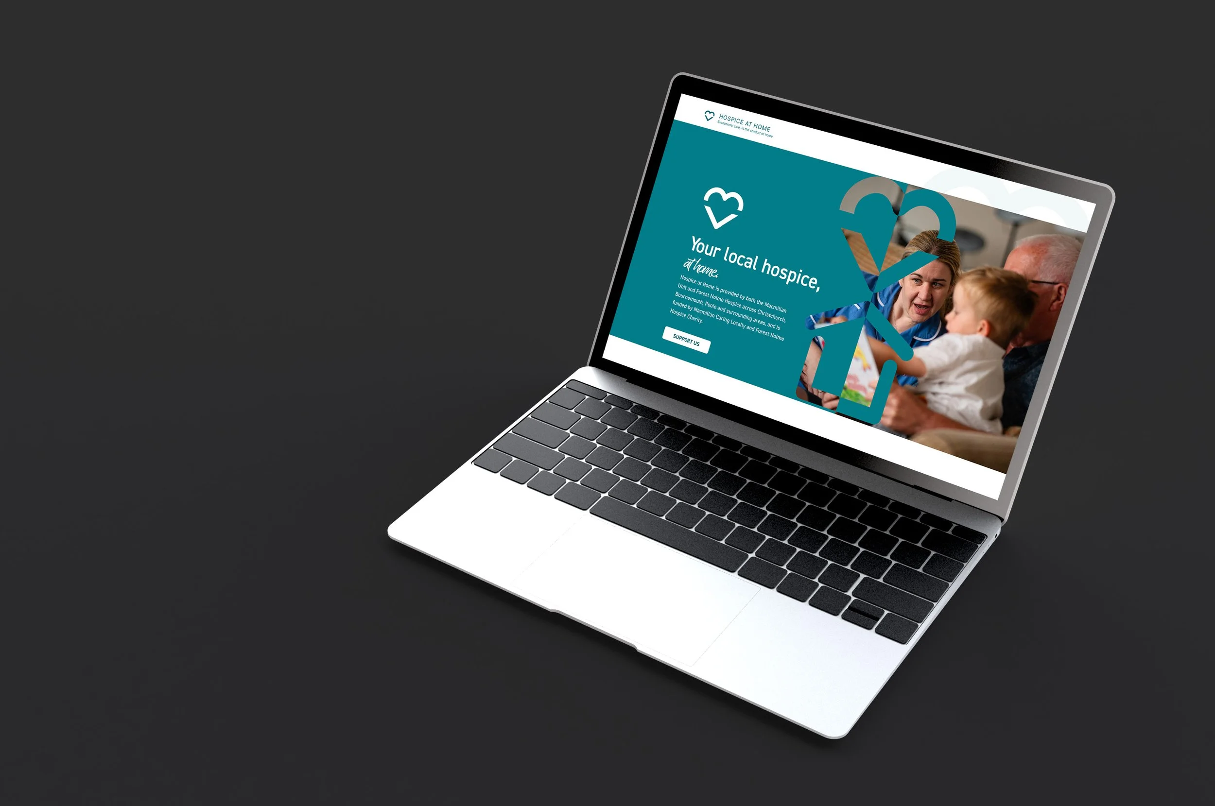 Laptop displaying a webpage for Hospice at Home, showing a photo of a healthcare worker talking to a child and an elderly man, with text about local hospice services.
