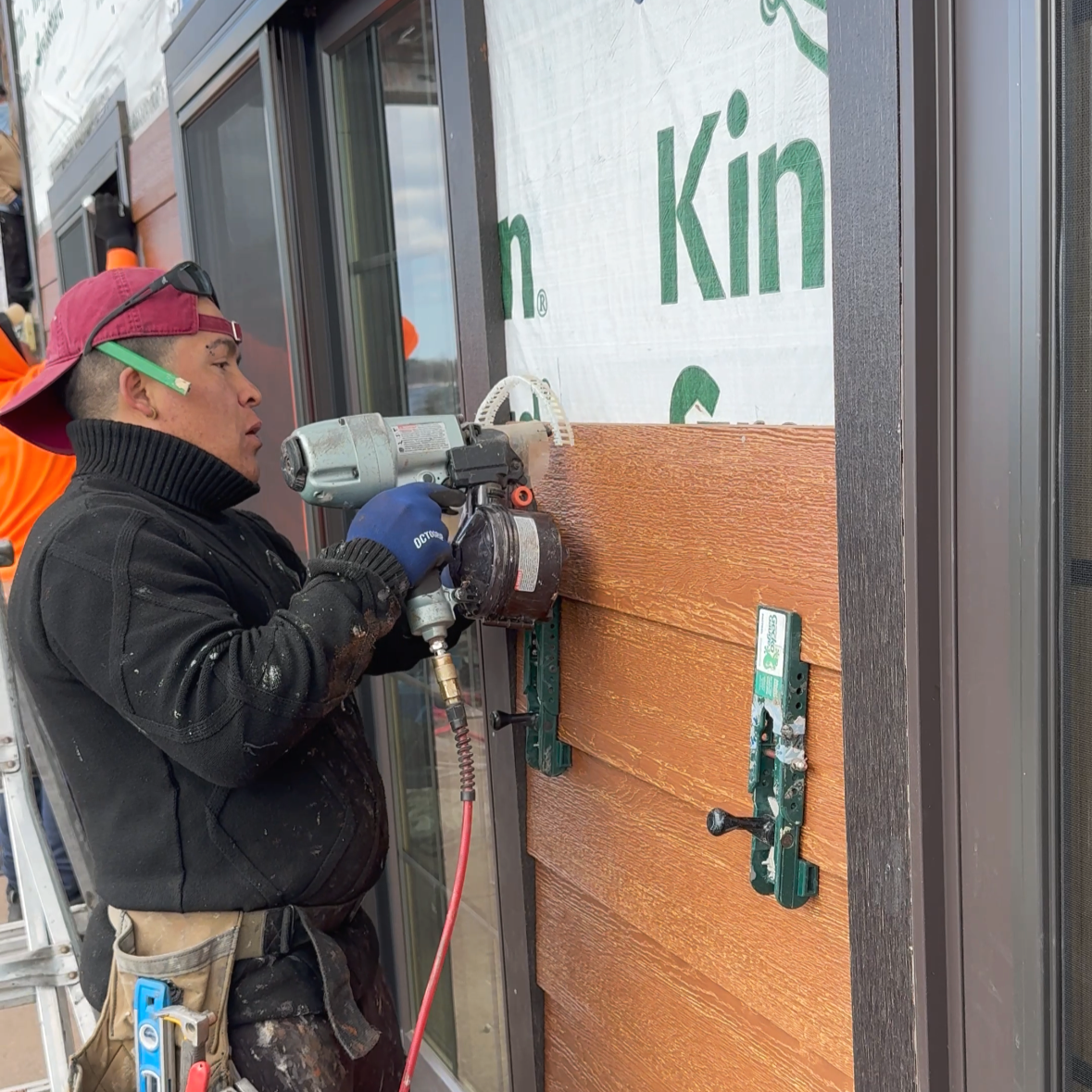 Citadel Construction installer using Gecko gauges for proper spacing while installing LP SmartSide lap siding over vapor barrier