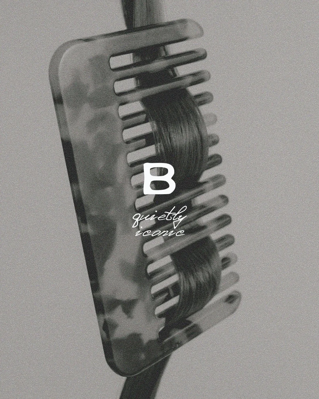 A black and white photo of a hair clipper with a guard attached. The clipper has a pad of hair wrapped around its blades. There is a large letter 'B' overlaid on the image along with the words 'quietly receive' in cursive script.