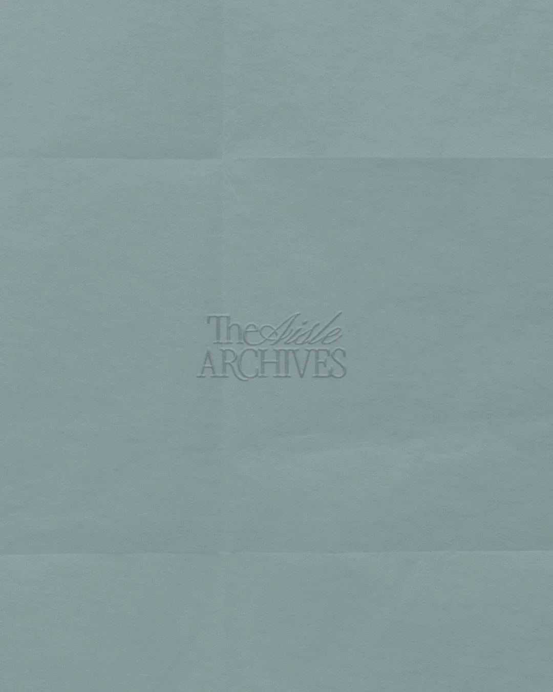 Light blue archival paper with embossed text reading 'The Aisle Archives'. Designed by brand designer Onassis Web Media.