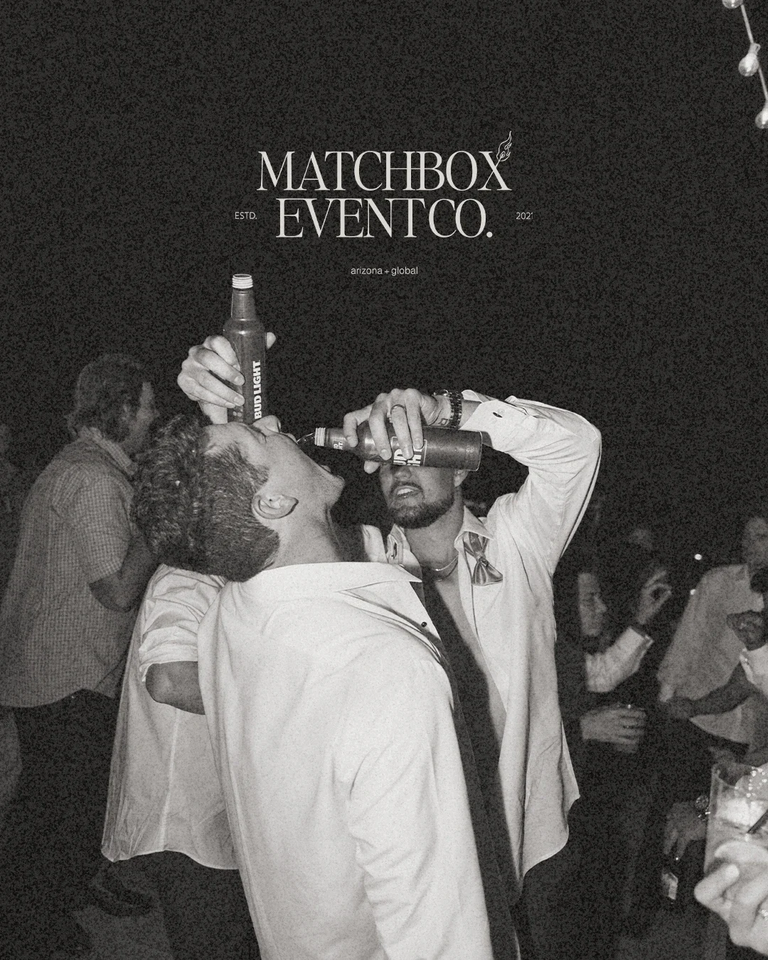 Two men at a party are drinking alcohol from bottles, with one tilting his head back and the other holding a bottle to his mouth. Several other people are visible in the background.