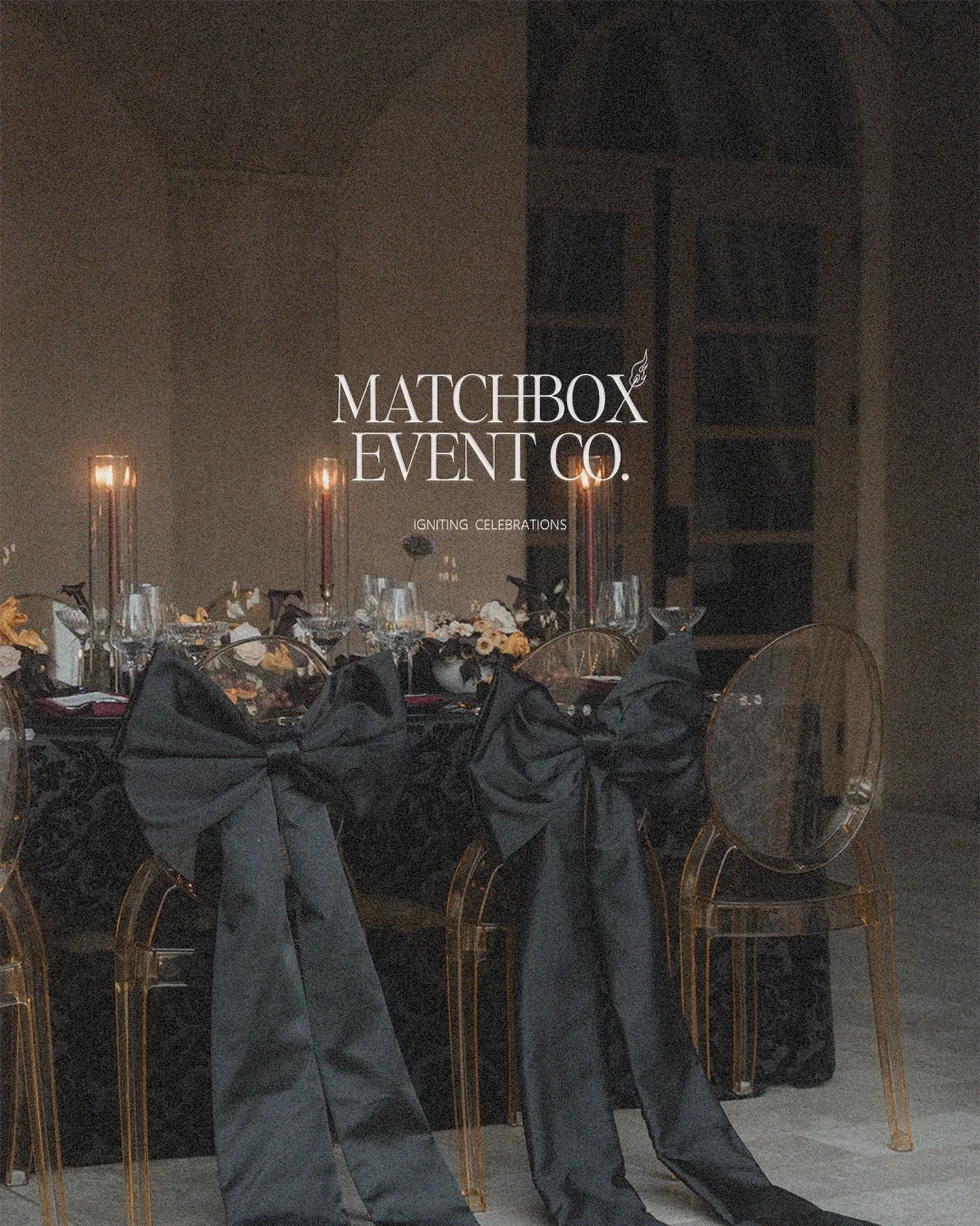 Elegant table setting for a formal event with black napkins tied into bows on gold chairs, floral centerpieces, and tall candles in the background, overlaid with the text 'Matchbox Event Co. Igniting Celebrations'.