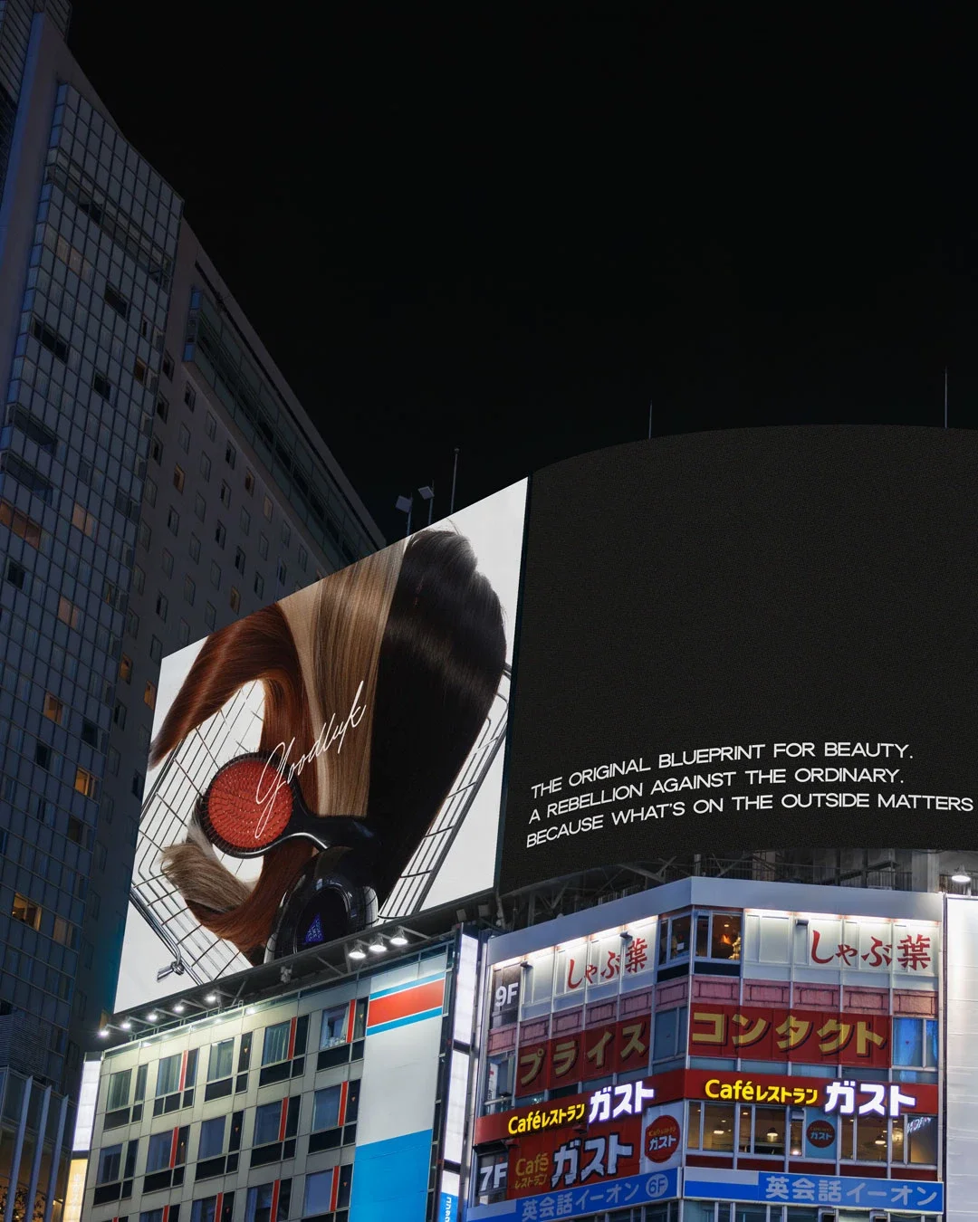 Nighttime cityscape with large digital billboards, including an advertisement for hair products and a message about beauty and outer appearance, above a building with Japanese signage.