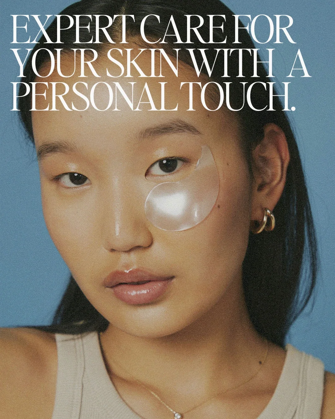 Close-up of a woman with a skincare eye patch, earrings, and a necklace, with text overlay that reads: "Expert care for your skin with a personal touch."