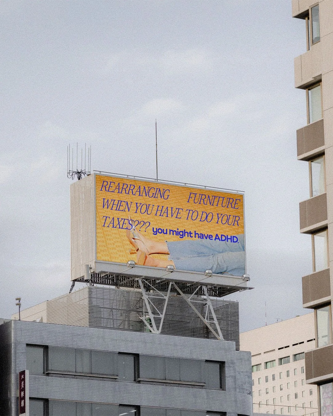 A billboard on top of a building with a humorous message that says "Rearranging furniture when you should be doing your taxes? You might have ADHD."