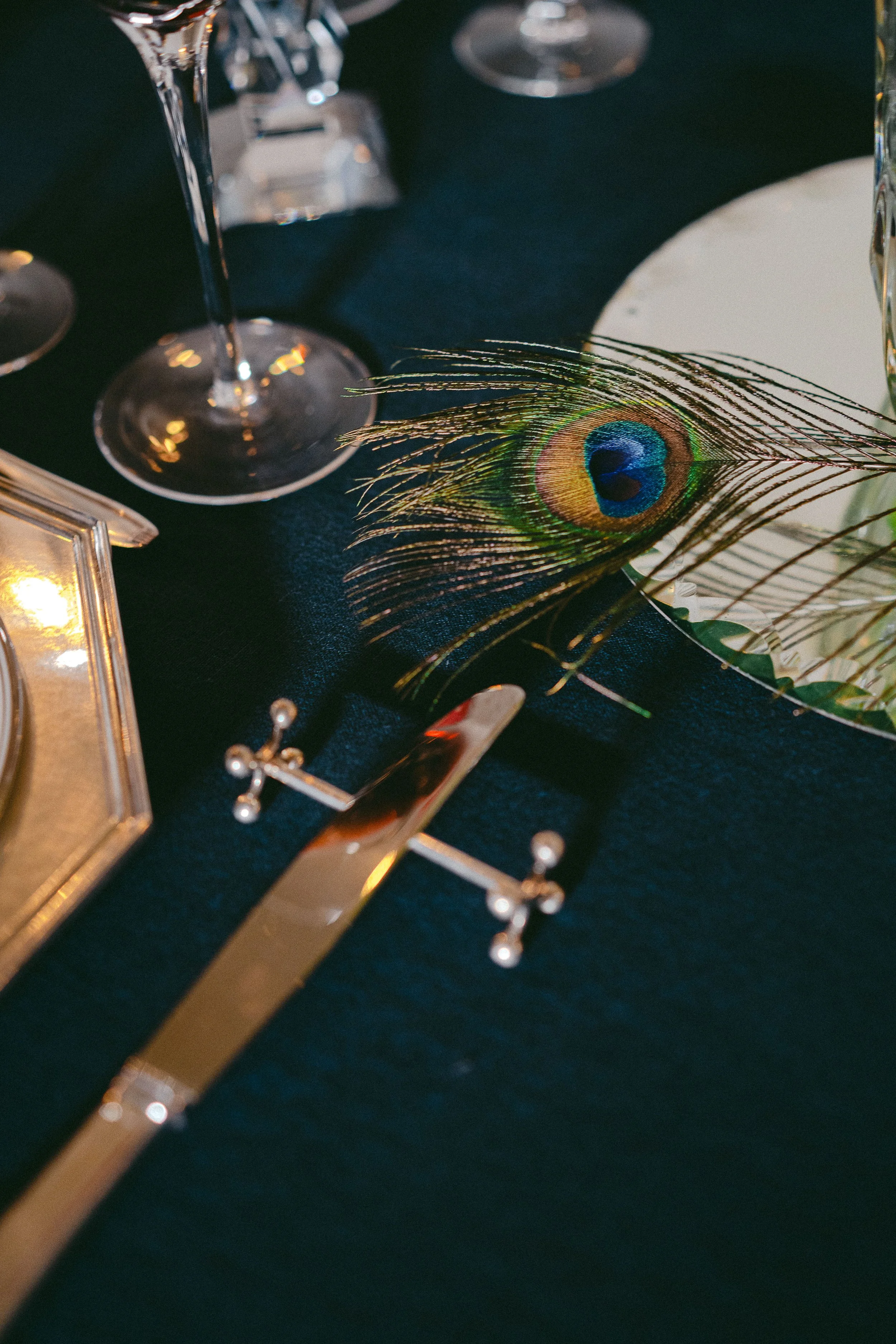 Plume de paon, couteau en argent, porte couteau Christofle, nappe bleue nuit